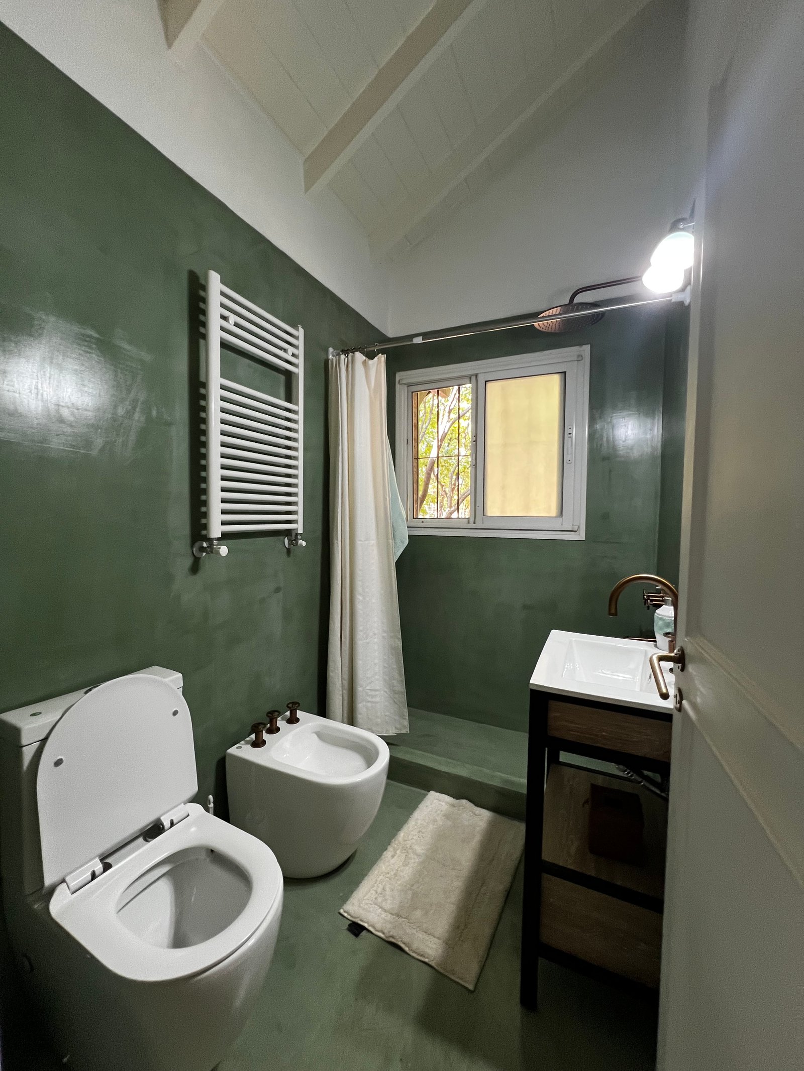 Baño moderno con paredes verdes texturizadas y techo inclinado — proyecto Argentino Golf , por Estudio NET Arquitectura , en Golf Club Argentino