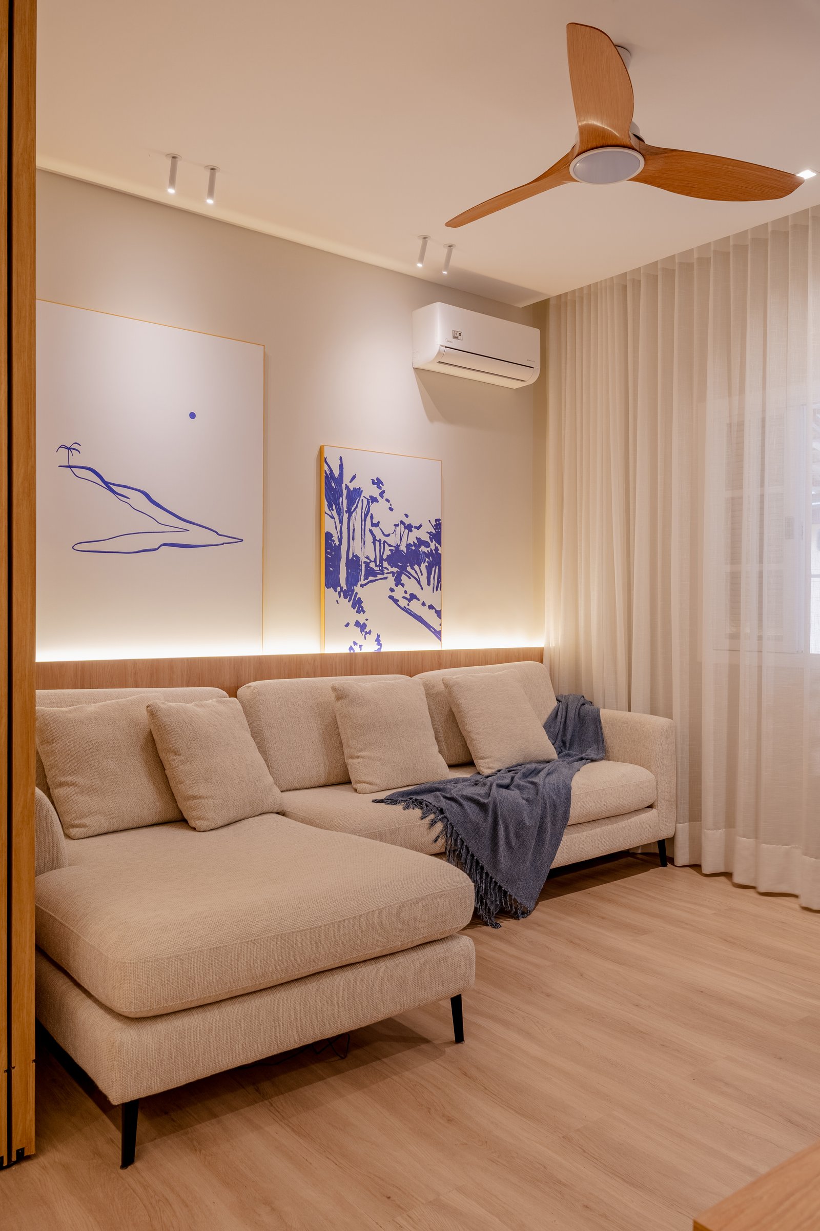 Sala de estar moderna com sofá seccional bege, arte minimalista e ventilador de teto — projeto Projeto DL, por Felipe Rohen, em Niterói