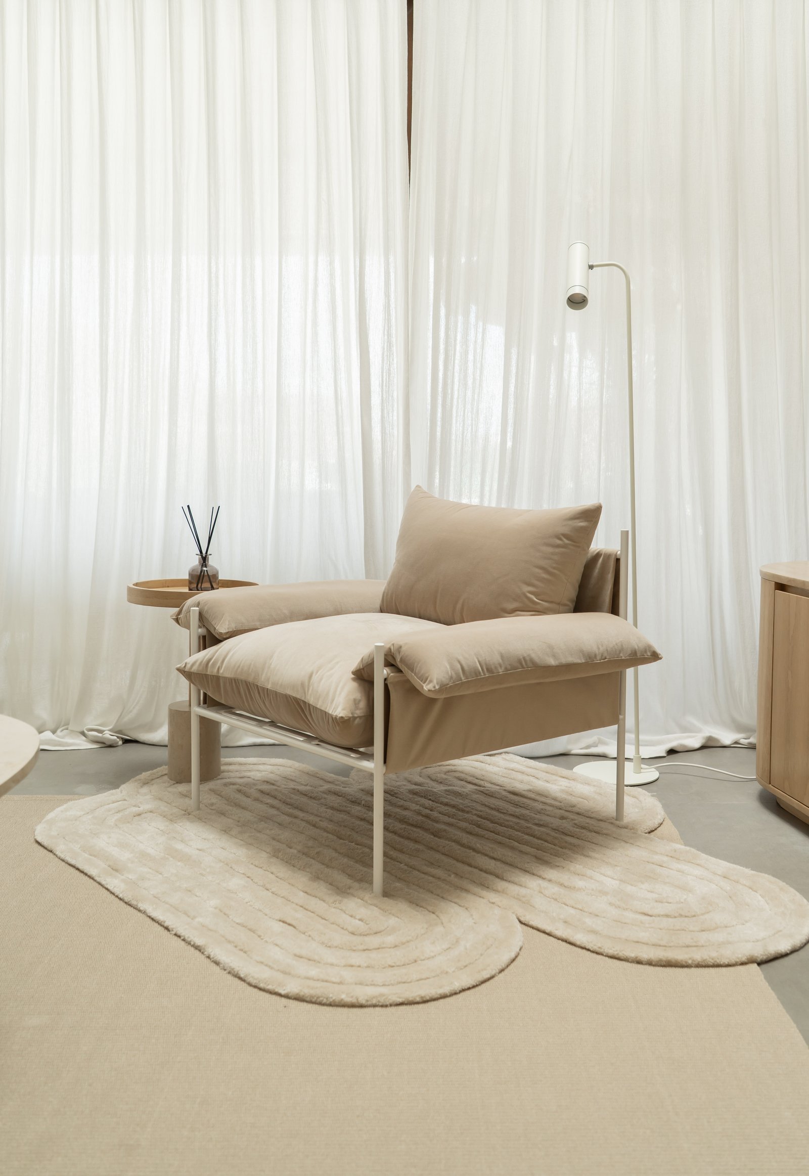 Sala minimalista com poltrona bege e cortinas brancas do chão ao teto — projeto PROYECTO NAUDIR, por July Acosta Home, em Belén de Escobar