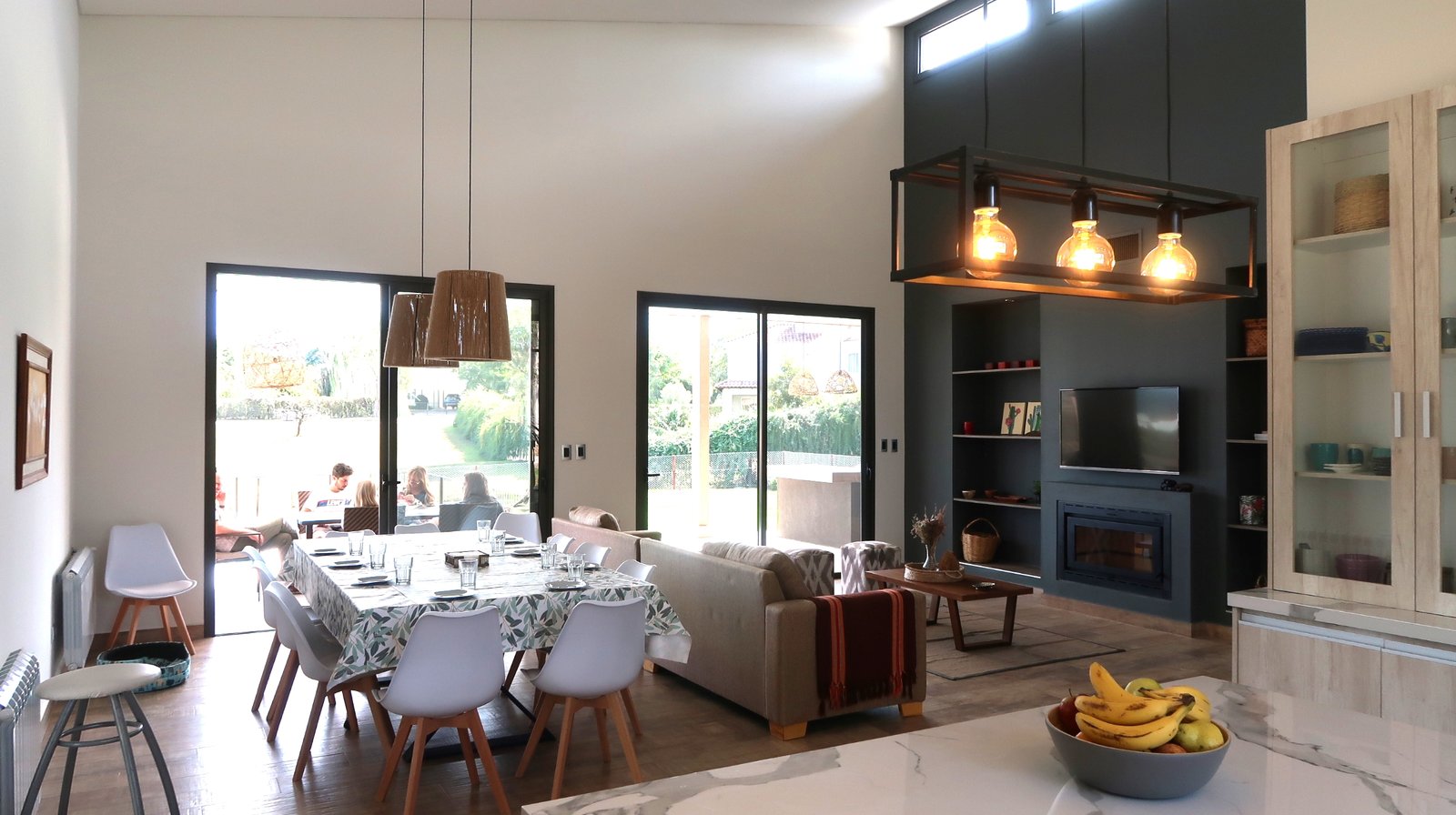 Sala de estar, jantar e cozinha integrados com pé-direito duplo e muita luz — projeto Casa La Paz, por Luciana González Anderson, em Salta