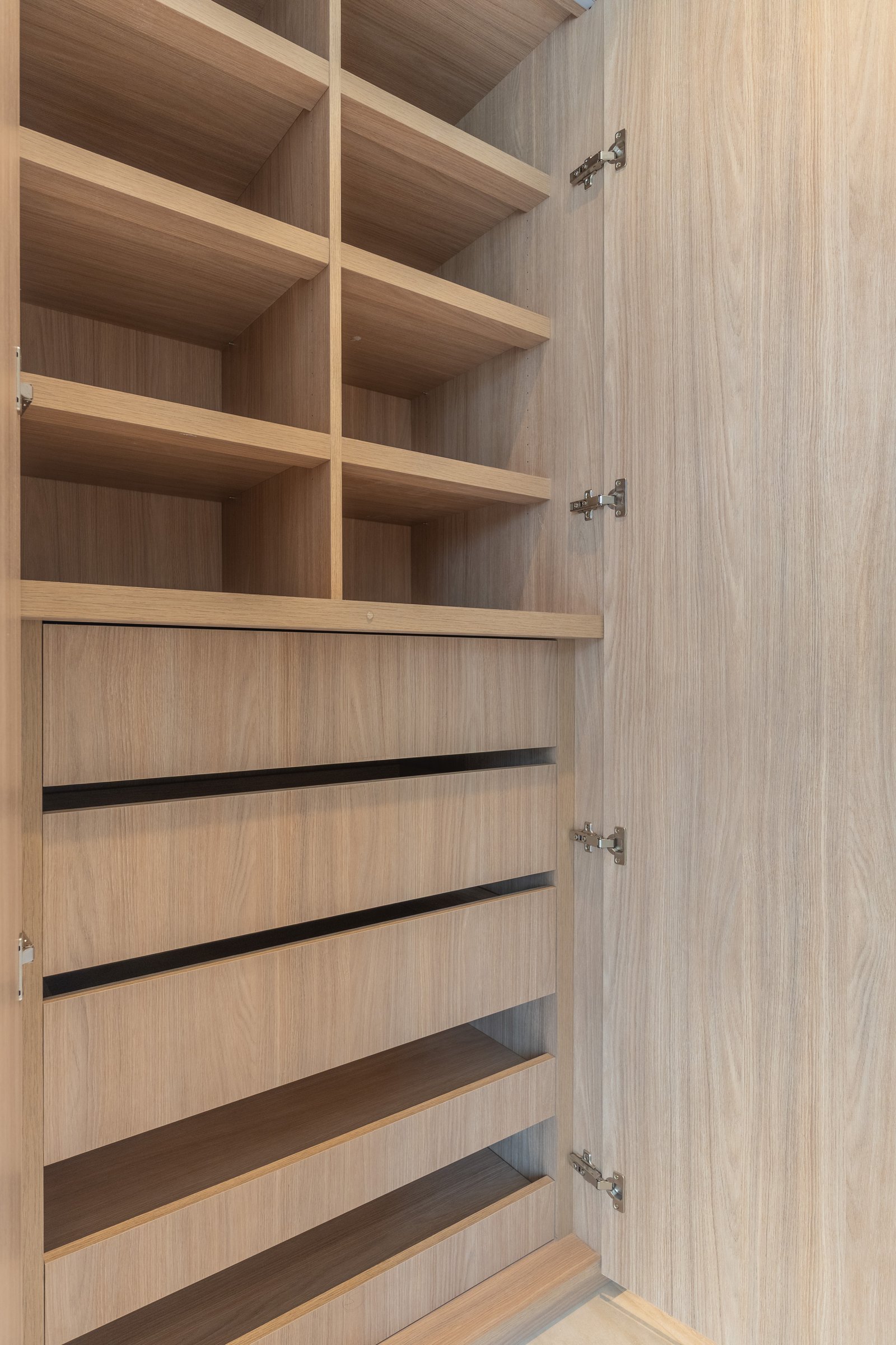 Interior de vestidor moderno con estanterías de madera — proyecto Yacht - Estudio CCWay, por ABEJA CONCEPT, en Av. de la Ribera 560