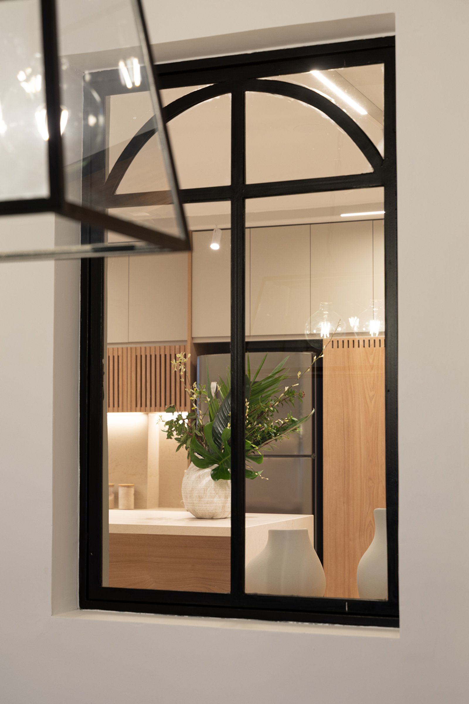 Cocina moderna con ventana arqueada y detalles en madera — proyecto Casa Ortega - Reforma Cocina, por Estudio Plats, en lavalle 2501