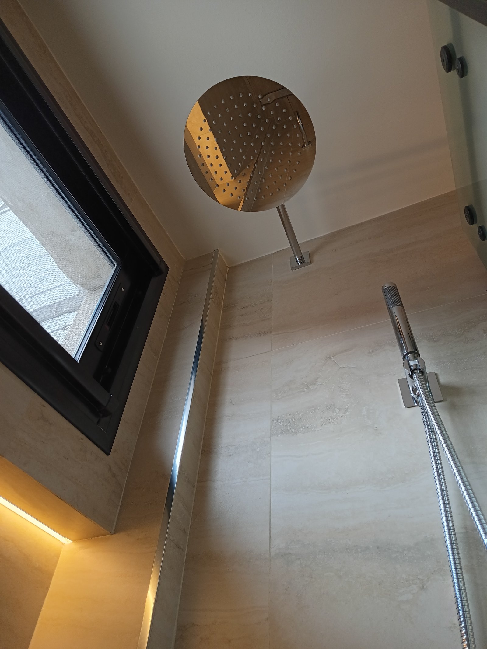 Baño moderno con ducha redonda empotrada y luz indirecta — proyecto Obra pelle, por vetainteriores, en Av. Carlos Pellegrini 1400
