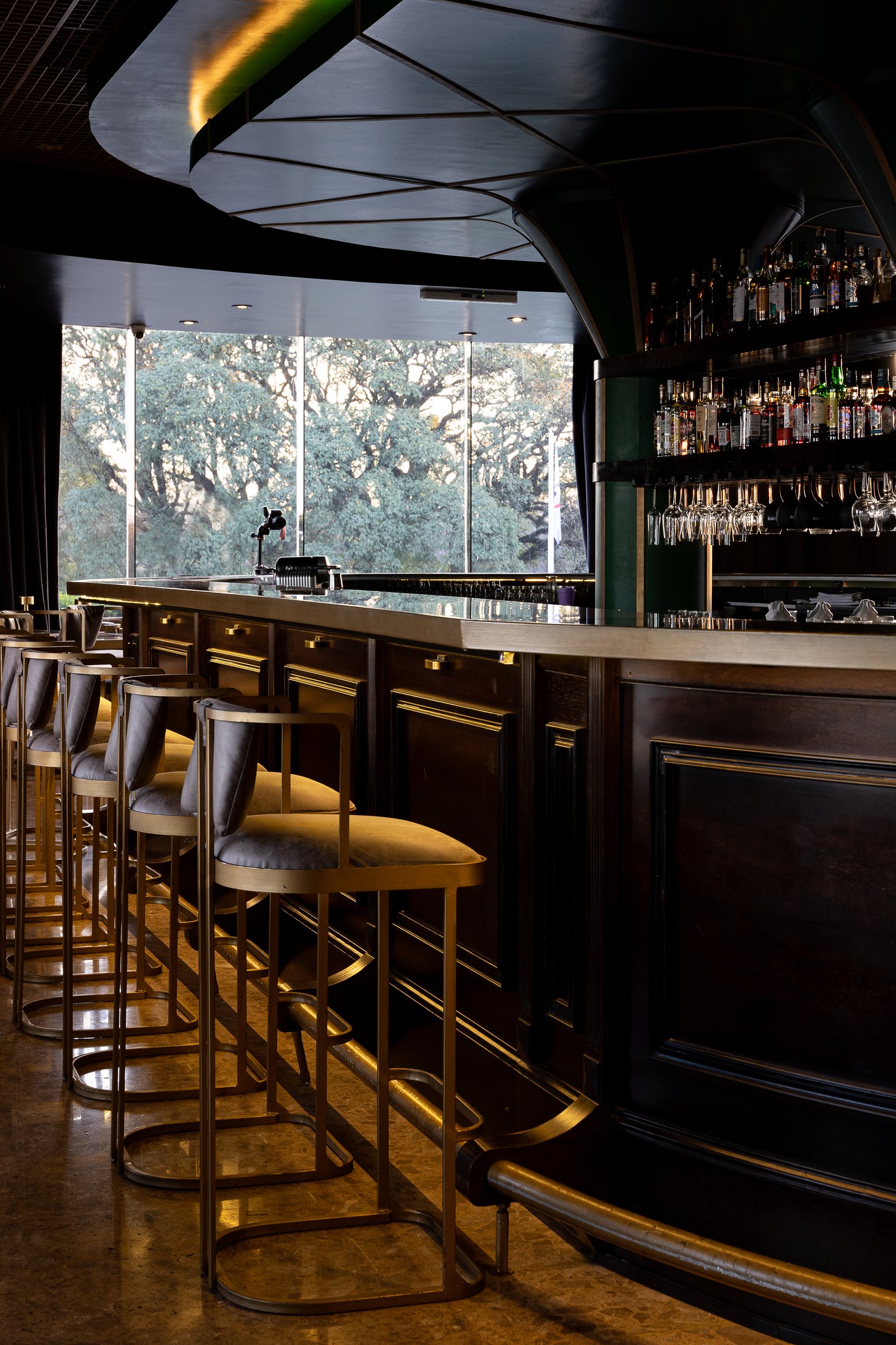 Bar moderno con banquetas, ventanales y vista a árboles — proyecto PRESIDENTE BAR HIPODROMO, por AB ARQUITECTURA, en San Isidro