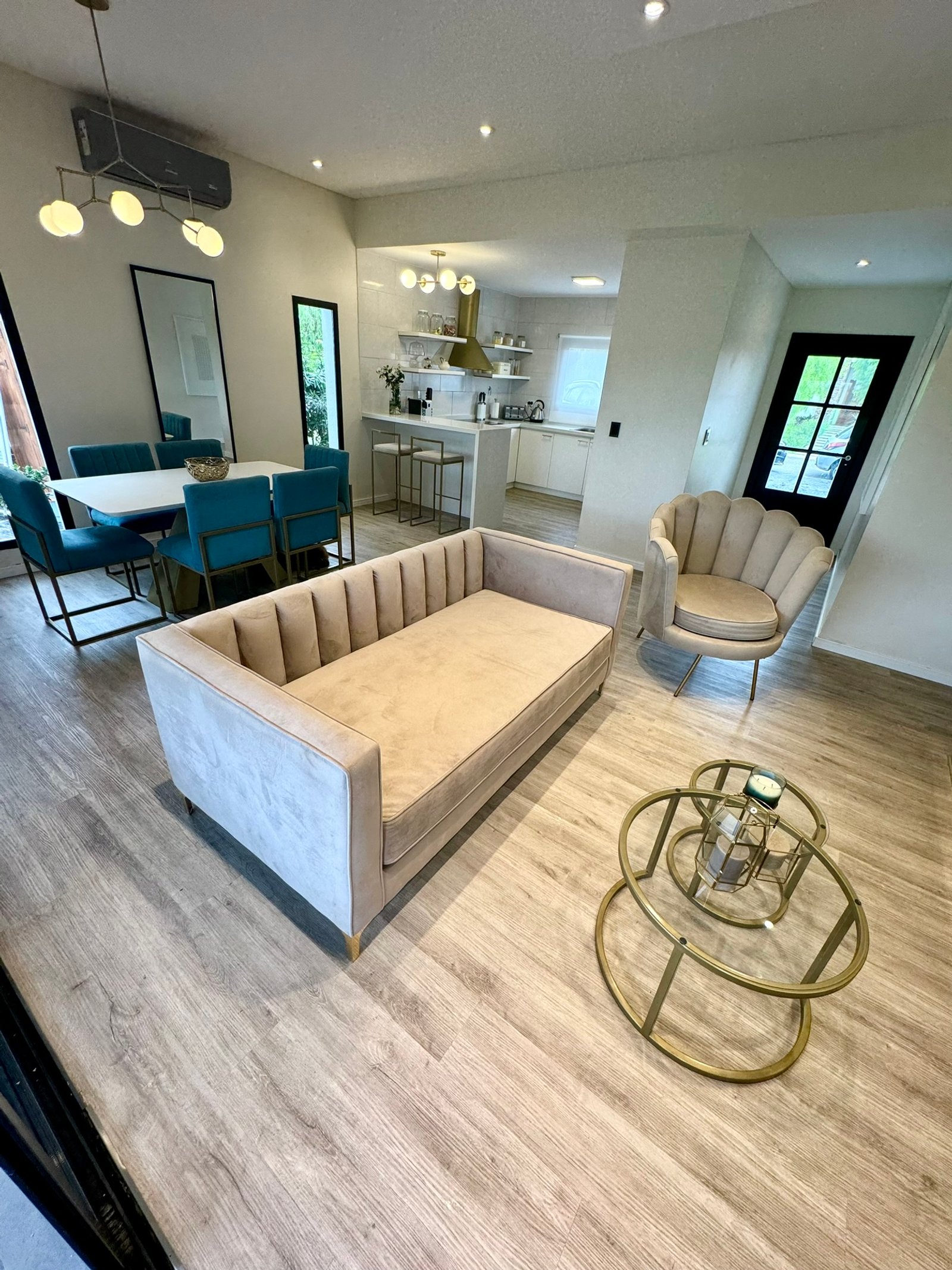 Living y comedor moderno de concepto abierto con muebles beige y turquesa — proyecto San Ramiro, por MDBK Arquitectura, en Pilar