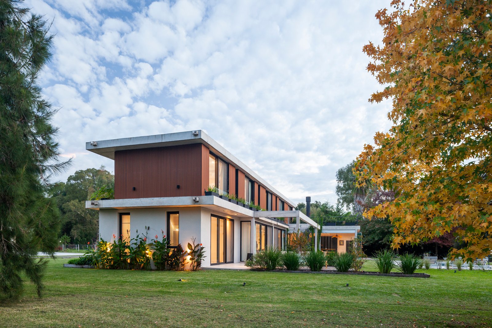 Fachada moderna con paneles metálicos y ventanales amplios — proyecto CASA HS143, por A'PRIMA - Arquitectura Sustentable, en km 7.5 Ruta 25