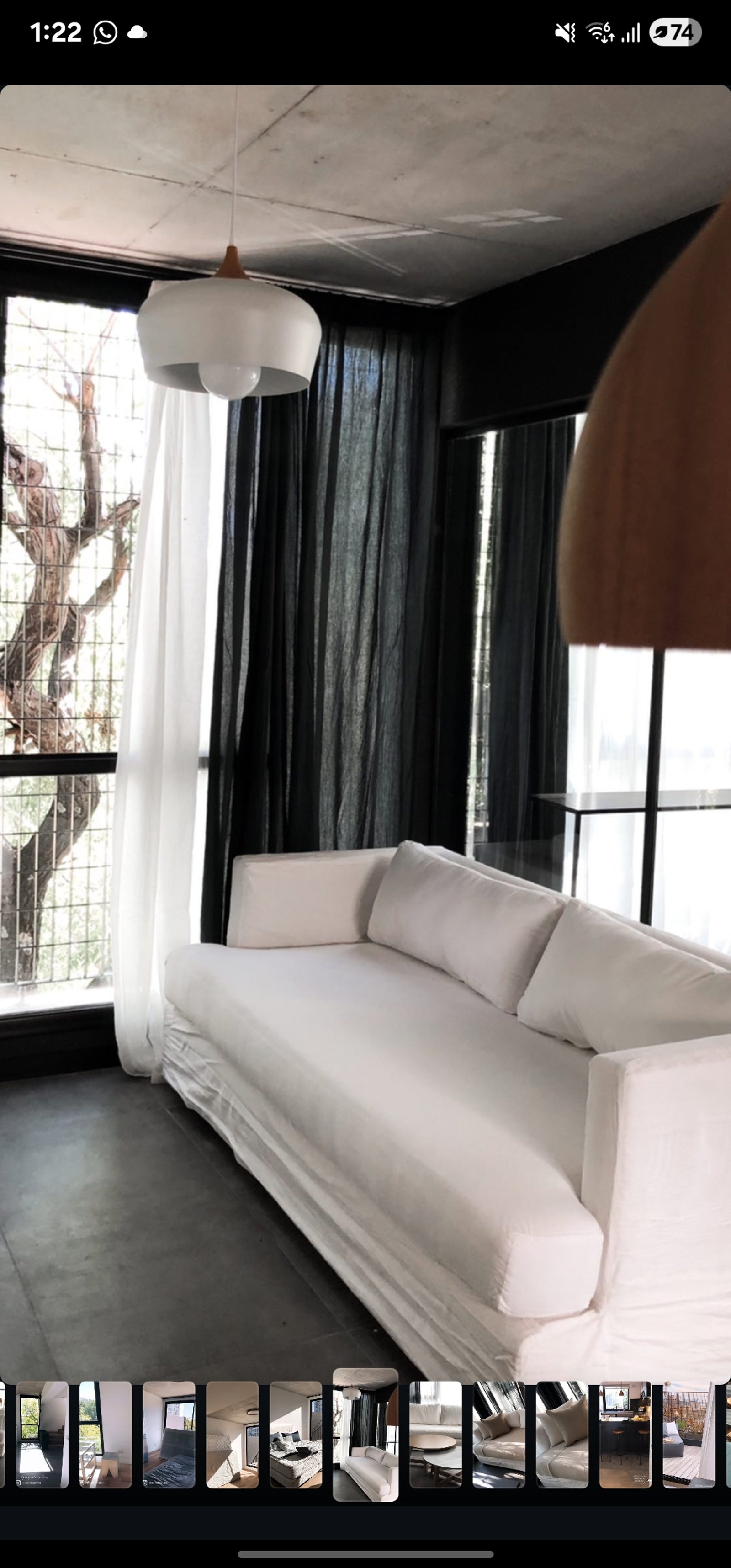 Sala moderna com sofá branco, cortinas de linho e piso de cimento — projeto Teodoro, por Claraboia, em Belgrano R