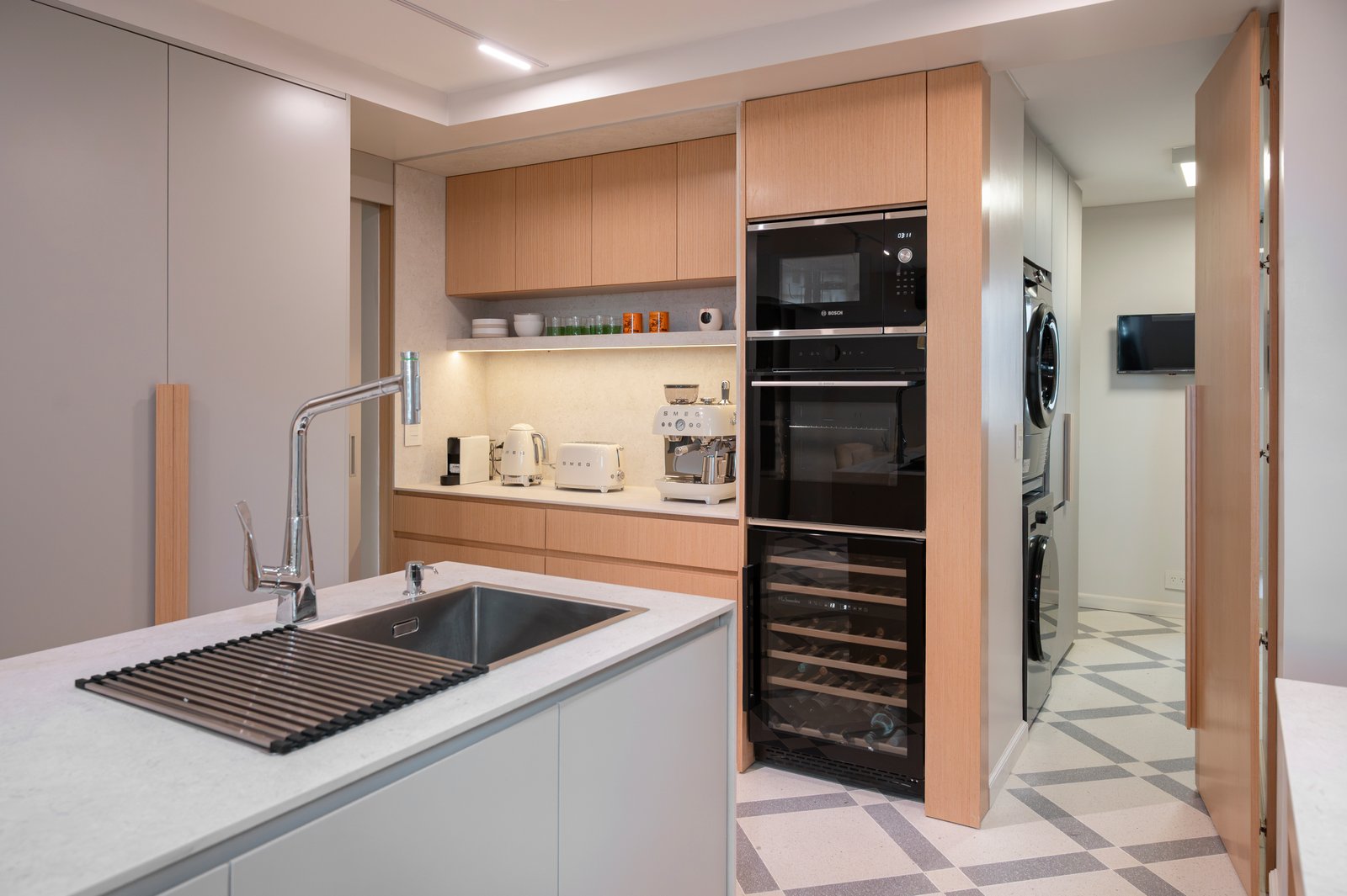 Cocina moderna con isla, gabinetes de madera y gris, y cava — proyecto ALVEAR TYM, por AB ARQUITECTURA, en Recoleta