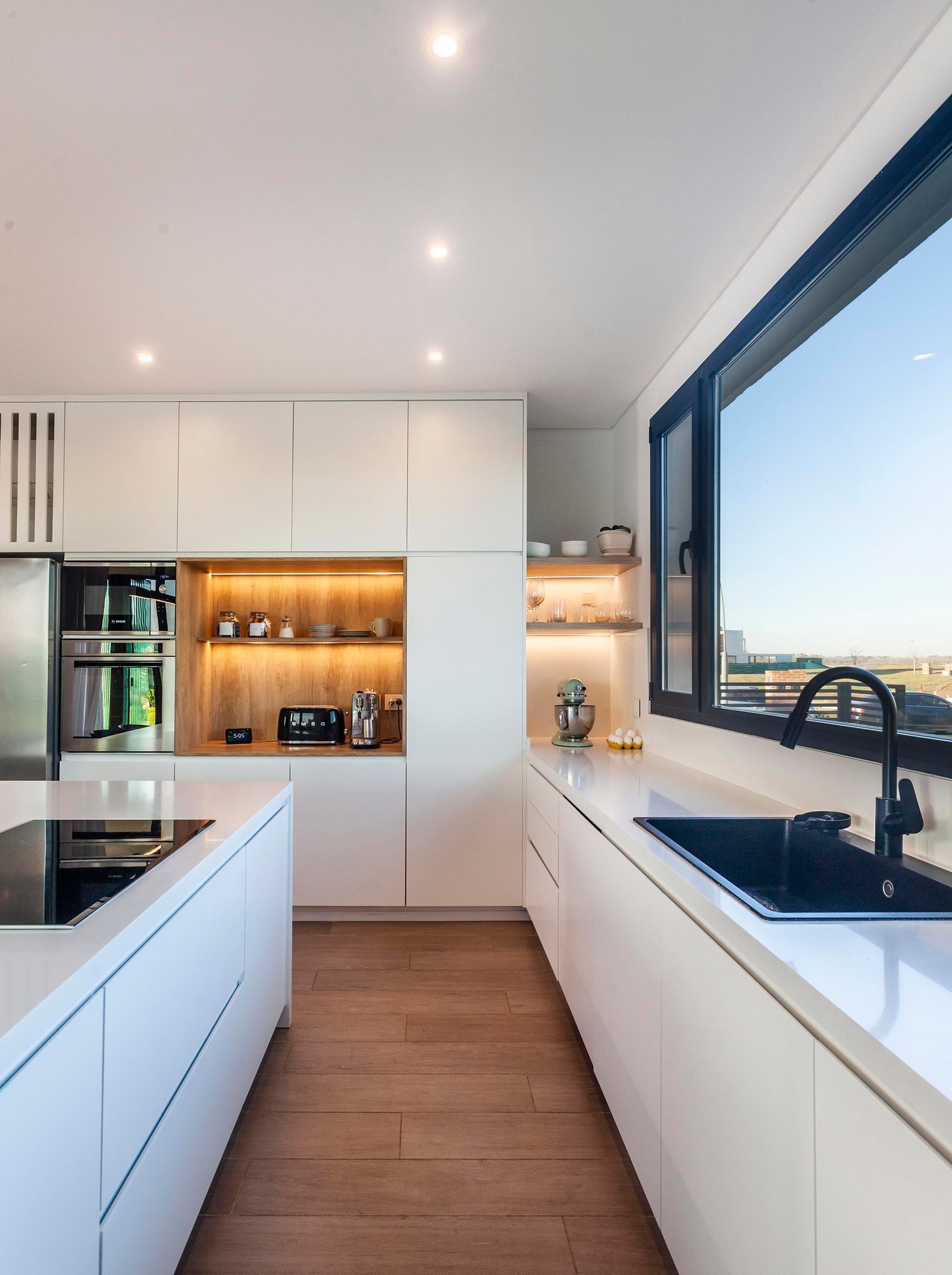 Cocina moderna de estilo escandinavo con gran ventanal — proyecto CASA C313, por A'PRIMA - Arquitectura Sustentable, en Provincia de Buenos Aires