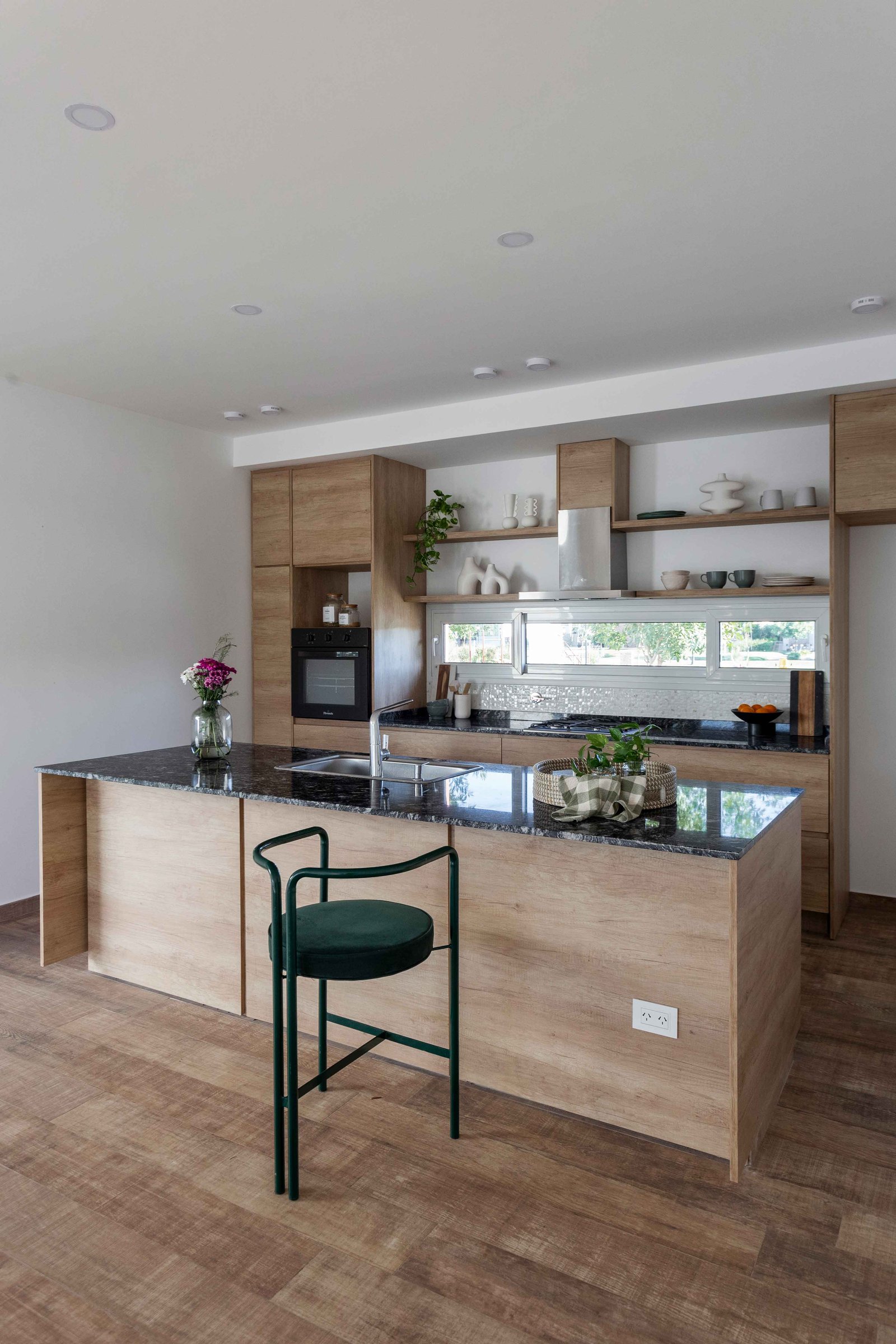 Cocina moderna con isla central y acabados en madera — proyecto Santa Ines II, por Estudio Stepa, en Ezeiza
