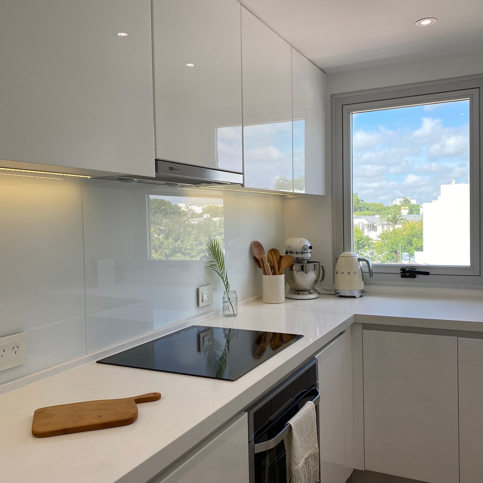 Cocina moderna blanca con encimeras de mármol y electrodomésticos integrados — proyecto Burela, por MDBK Arquitectura, en Villa Urquiza