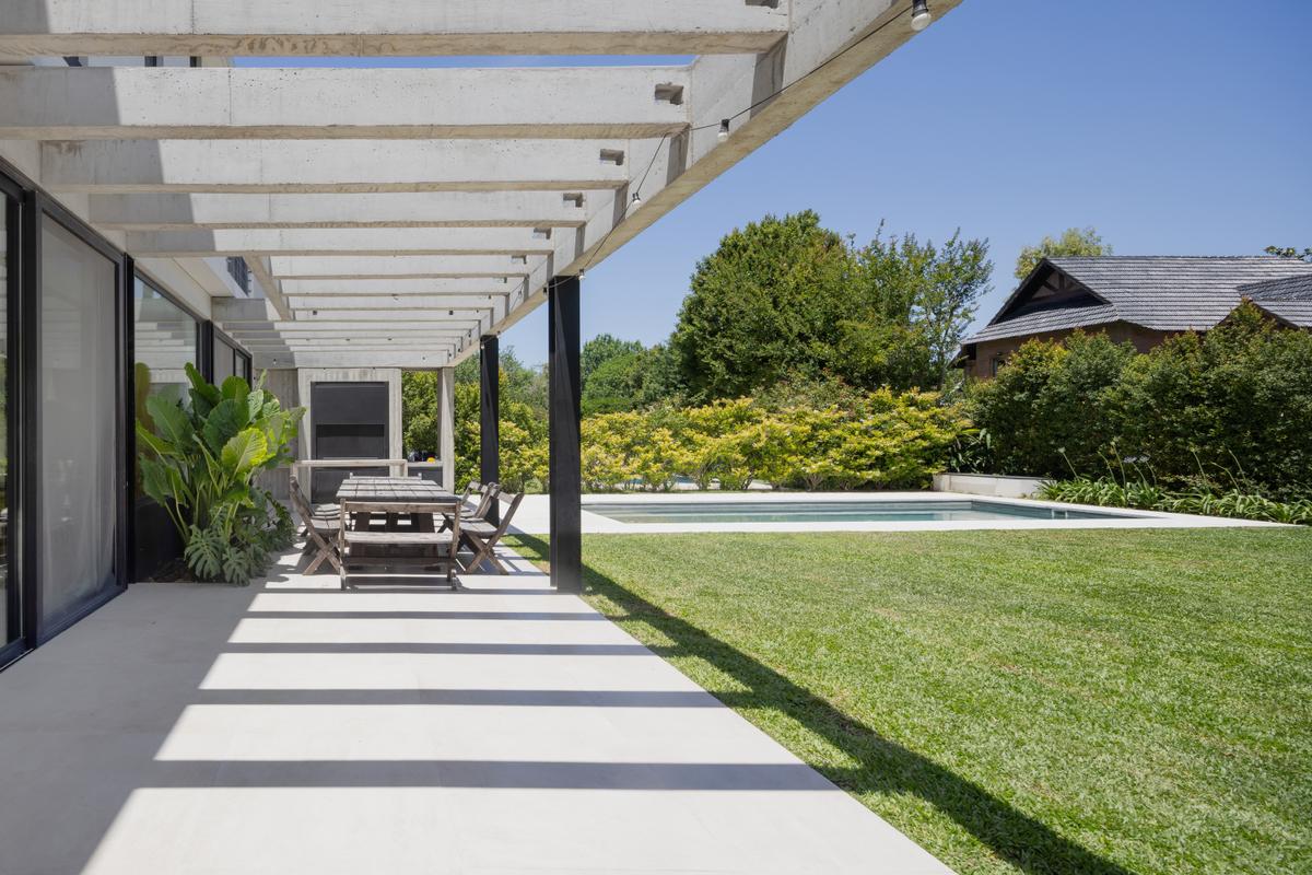 Pérgola de concreto com sombras sobre pátio e piscina — projeto CASA RuZa, por Alfredo Orfila arquitectura, em Benavidez