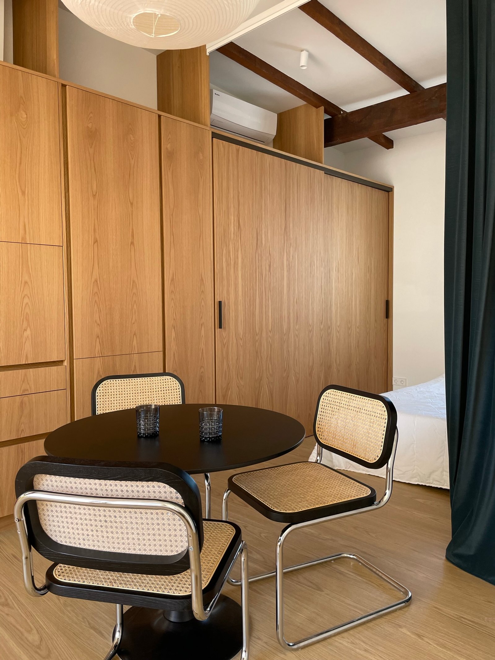 Comedor moderno con muebles de madera y ratán — proyecto Burriana, por JT ARQUITECTURA, en Valencia