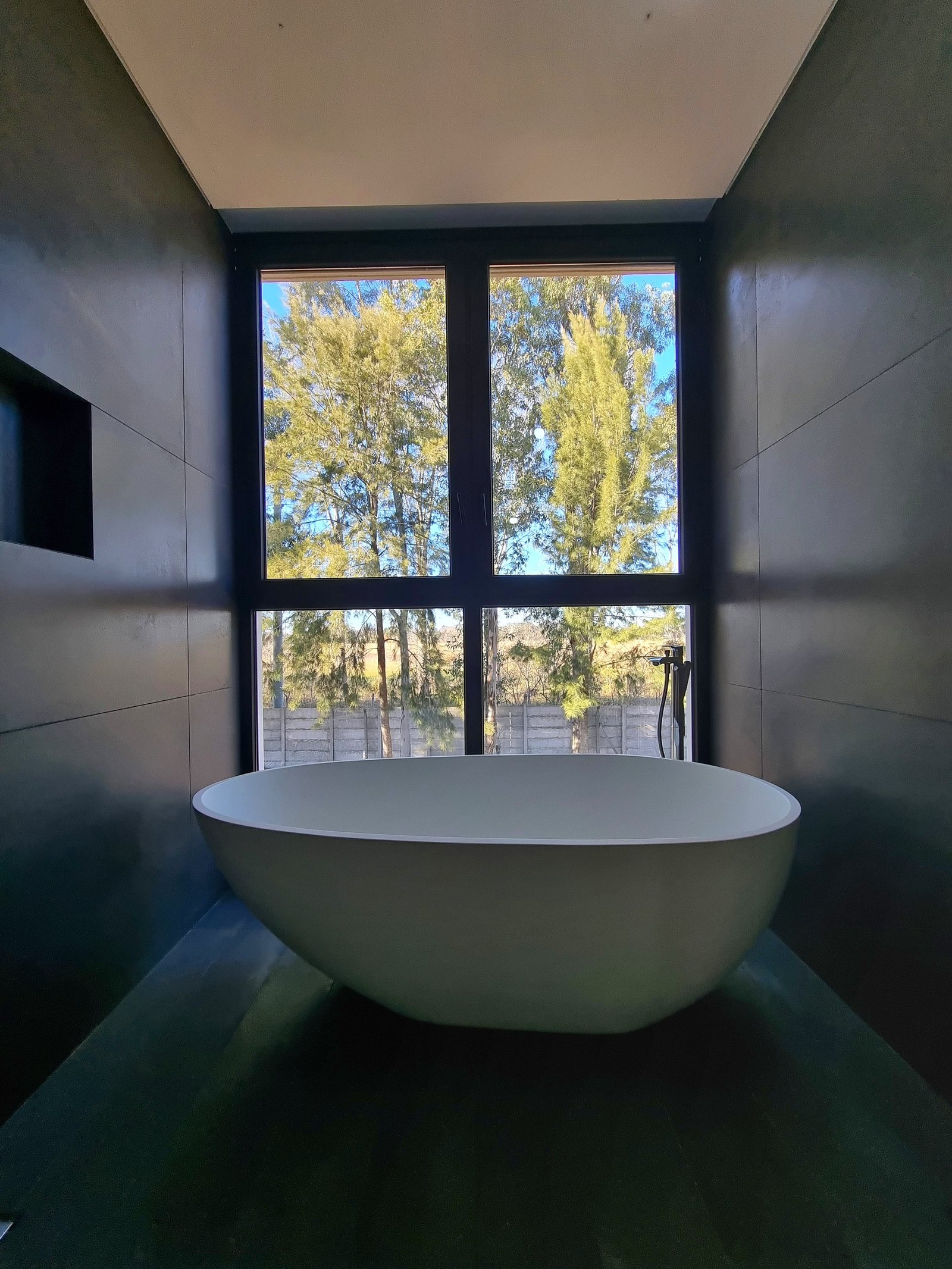 Baño moderno con bañera exenta y grandes ventanales — proyecto CASA T199, por A'PRIMA - Arquitectura Sustentable, en Los Robles 5901