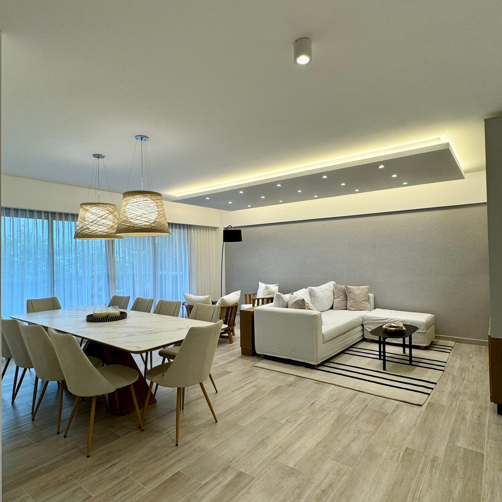 Comedor y living moderno con mesa de madera y sillones grises — proyecto Frias, por MDBK Arquitectura, en Villa Crespo