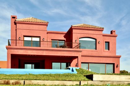 Casa terracota estilo mediterráneo con ventanales y balcones — proyecto San Marcos 2, por Marconi Silva Arquitectos, en Benavidez
