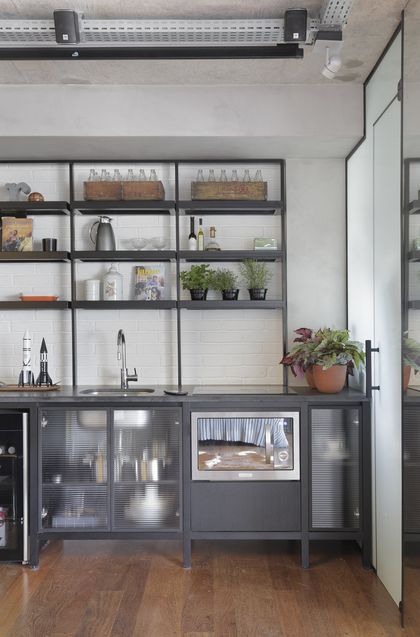 Cocina industrial con estantes abiertos, mesada madera y plantas decorativas — proyecto RA Loft, por Studio Ro-ca