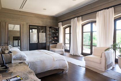 Dormitorio principal minimalista con ventanales, madera natural y tonos beige — proyecto Casa Toscana , por Estudio Du 