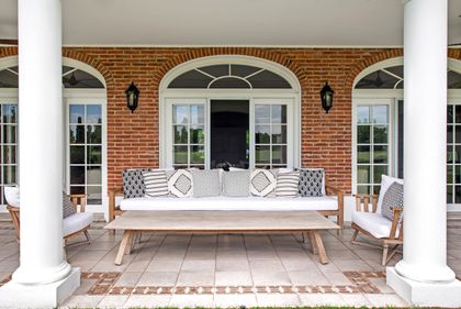Galeria clasica con columnas blancas, sofa y sillones de madera — proyecto Casa Tortugas , por Estudio Du , en Tortugas Country Club