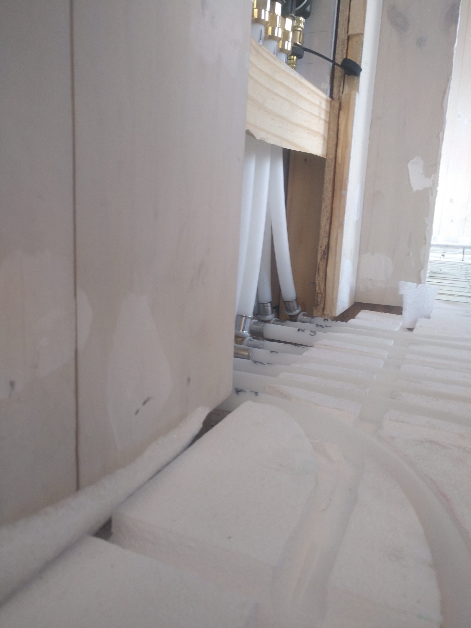 cañerías blancas bajo viga de madera en obra — proyecto Vivienda Lago Lolog, por TROKEN, en Neuquén