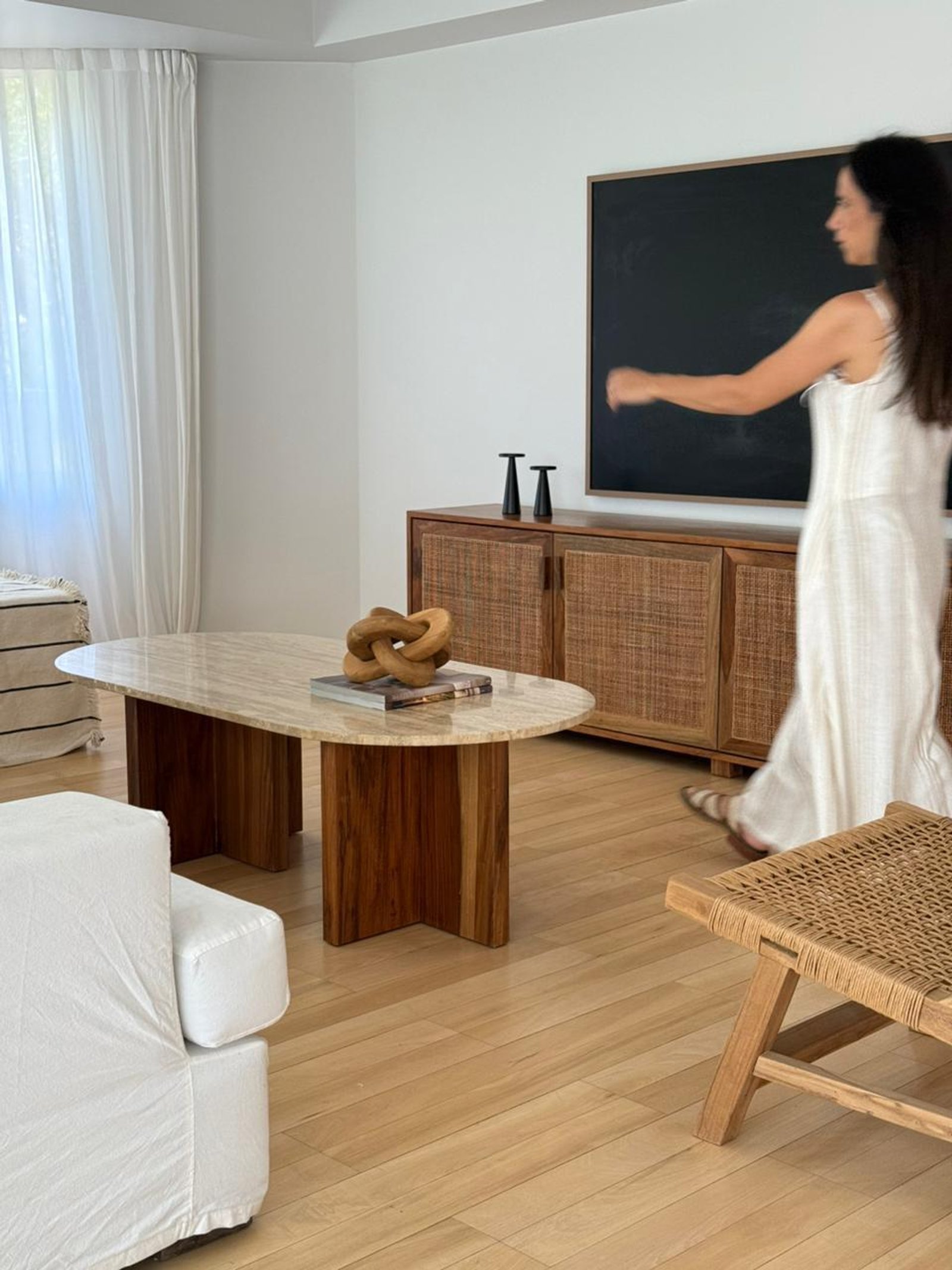 Sala de estar moderna con sofá blanco, mesa de travertino y mueble de ratán — proyecto LIBERTADOR, por CUFANIA HOME , en La Lucila