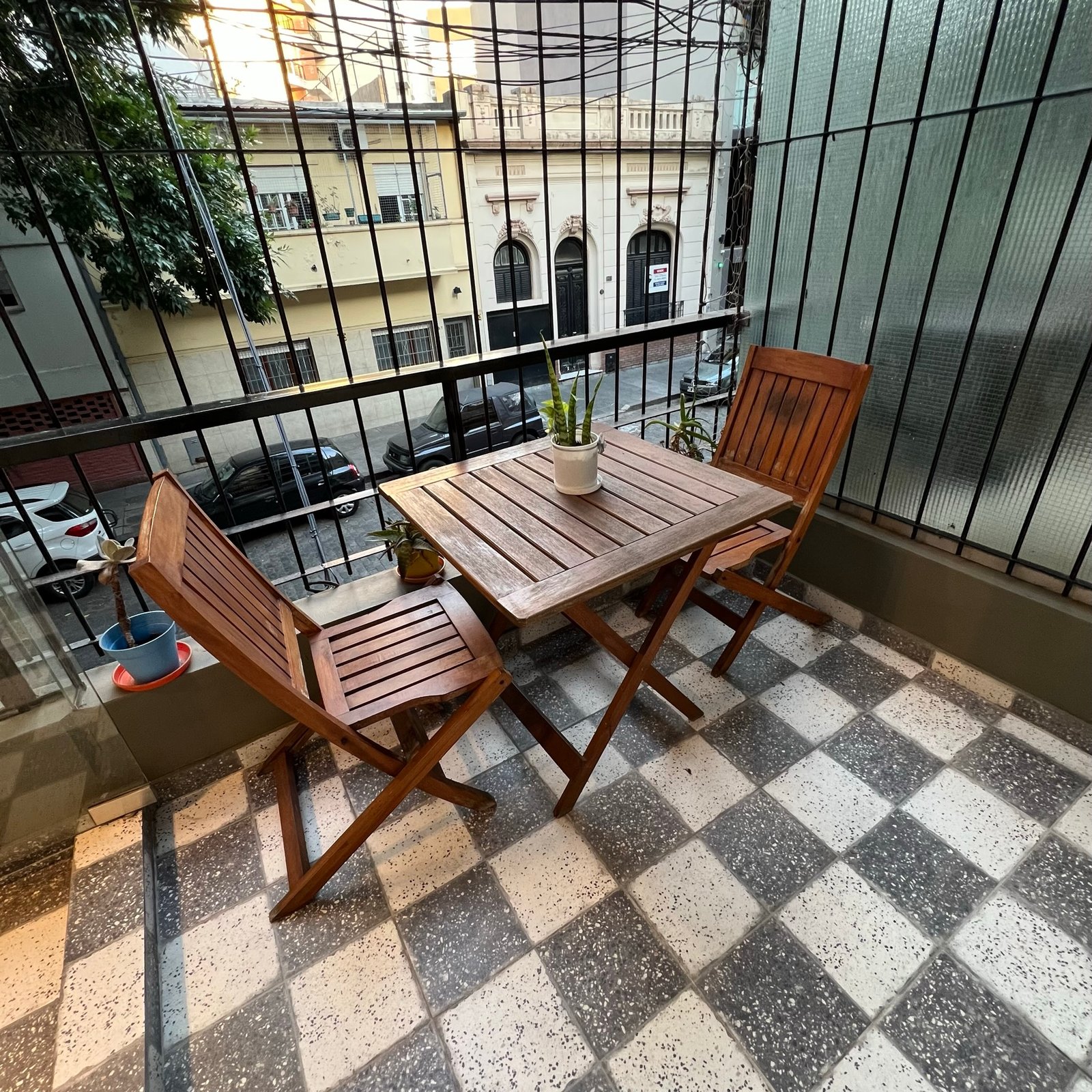 Balcón urbano con deck a cuadros y muebles plegables — proyecto Epuyen II, por MDBK Arquitectura, en Caballito