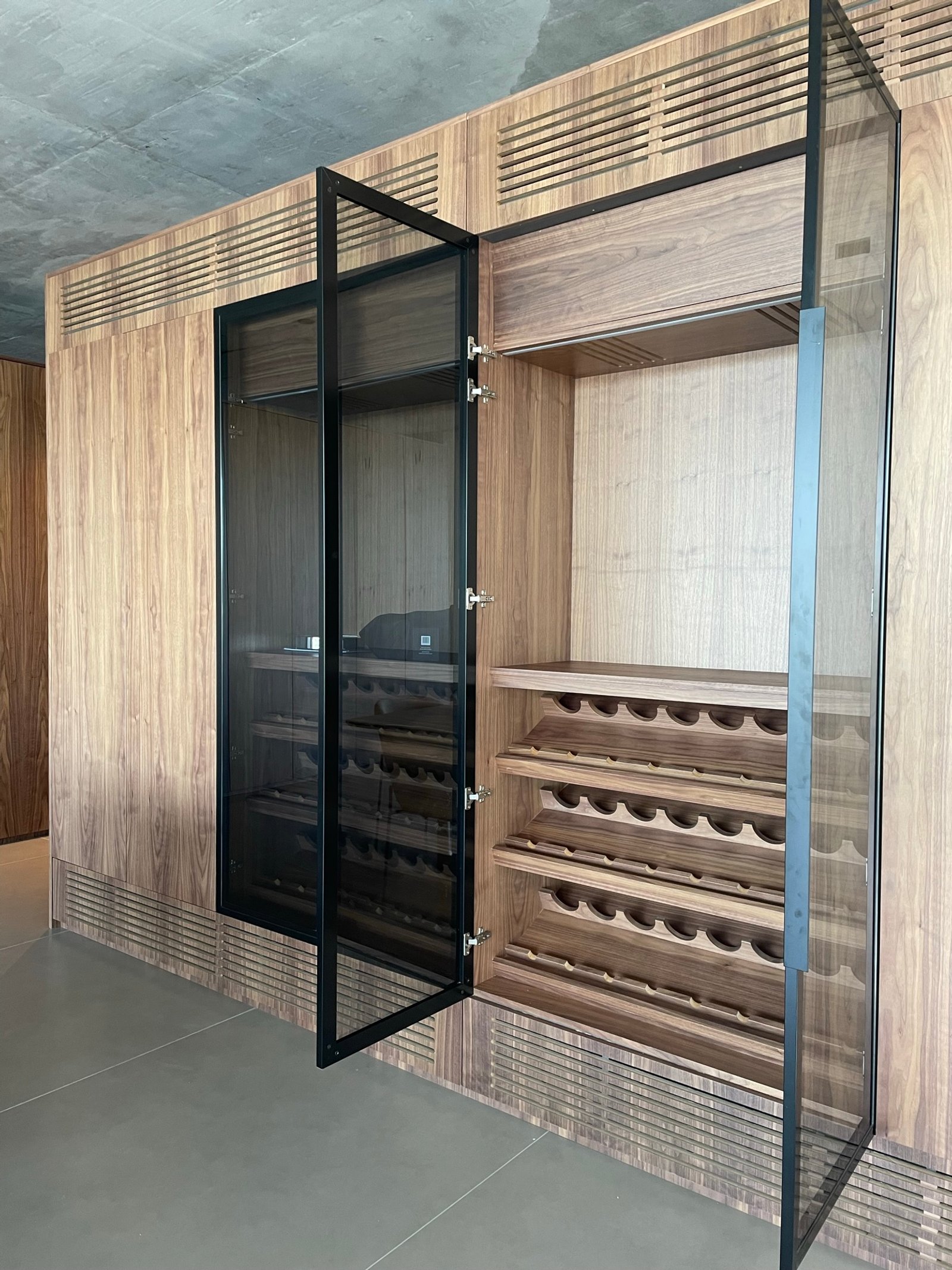 bodega moderna integrada con puertas de cristal y estanterías de madera — proyecto Albanueva - Estudio Amado Cattaneo, por ABEJA CONCEPT, en Nordelta