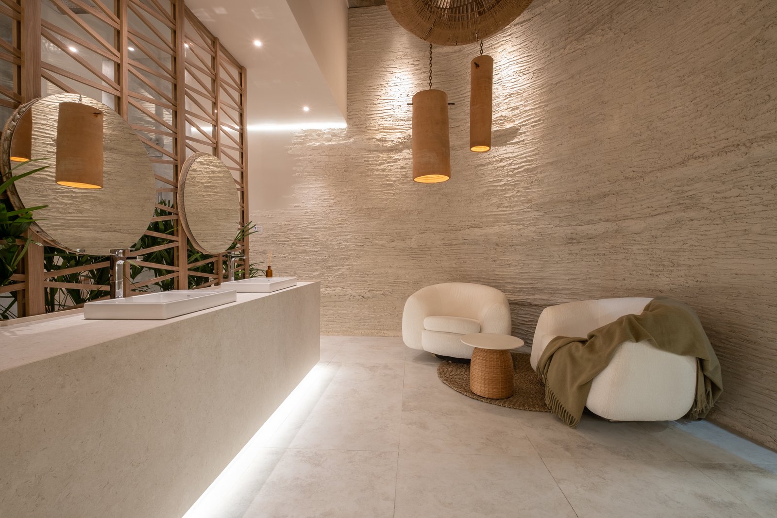 Baño moderno con pared de piedra texturizada y muebles curvos — proyecto Marmoles, por Vite Porcellanato