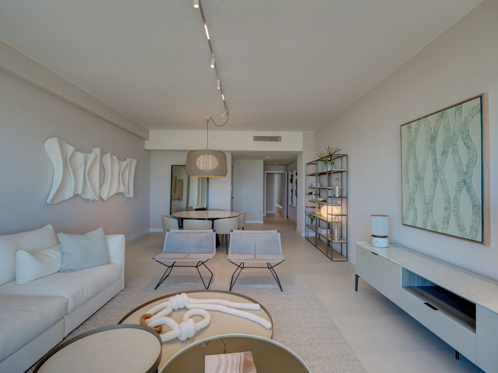Living comedor moderno minimalista con sofá curvo y detalles en rattan — proyecto LE PARQ TORRE IV , por ILVA, en Provincia de Buenos Aires