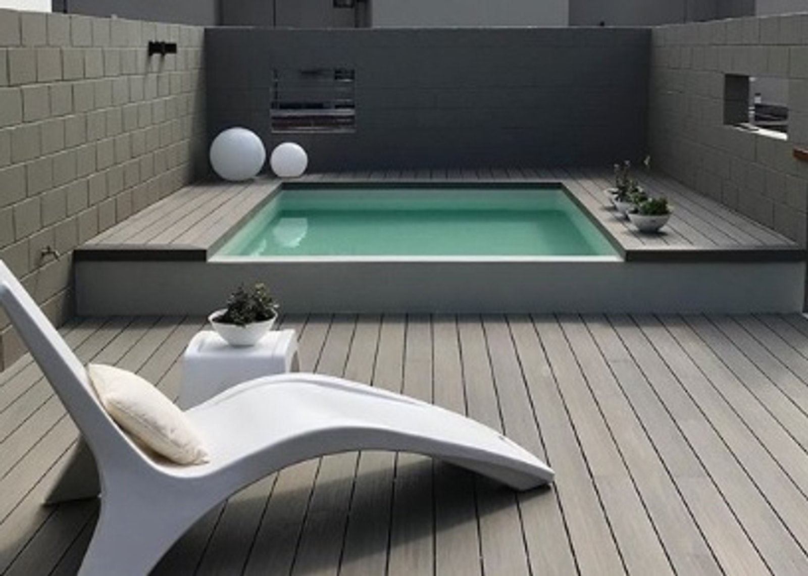 Piscina moderna al aire libre con deck de madera y lounge blanco — proyecto Outdoor, por The Flooring Company