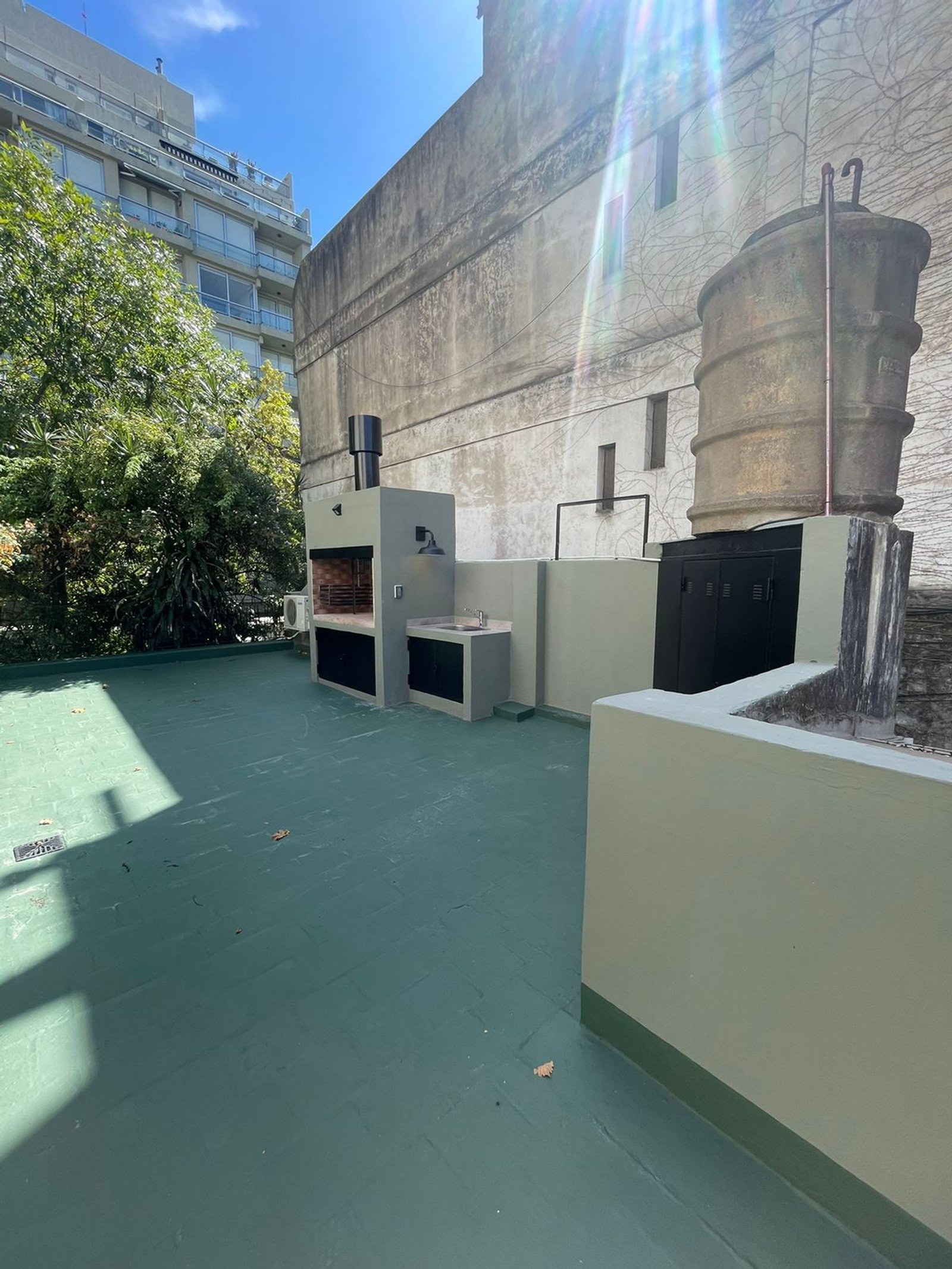 Terraza con parrilla y tanque de agua en azotea — proyecto Carranza , por Estudio NET Arquitectura , en Adolfo P. Carranza 2263