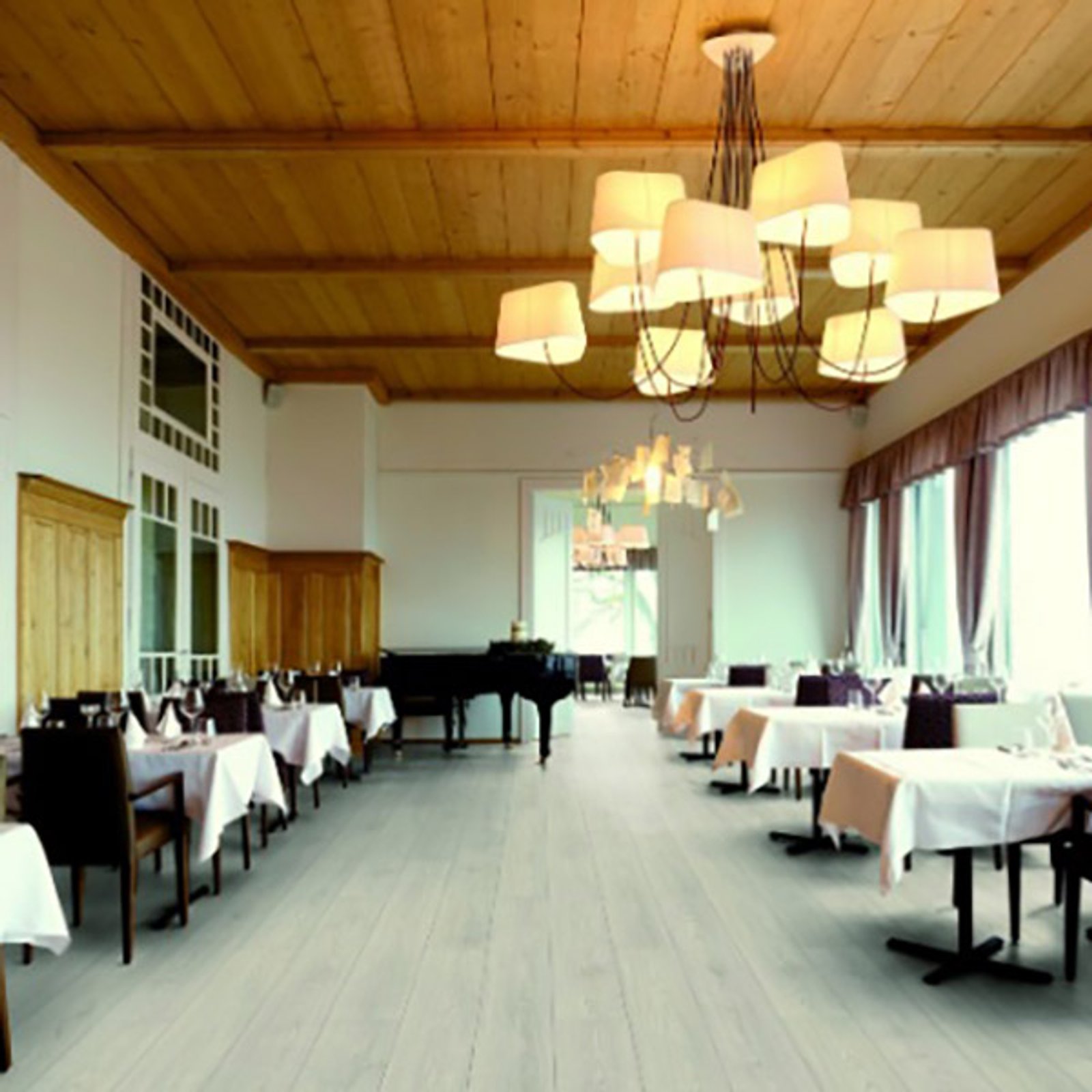 Salón de eventos con araña gigante y piano de cola — proyecto Pisos Flotantes, por The Flooring Company