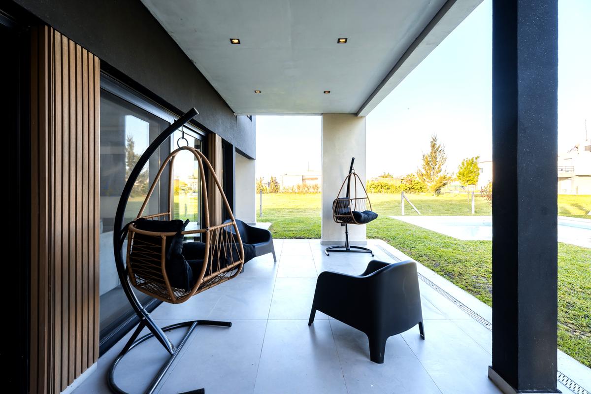 Varanda moderna com cadeiras de baloiço em vime e detalhes em madeira — projeto Casa ALM57, por EZ architects, em Canning