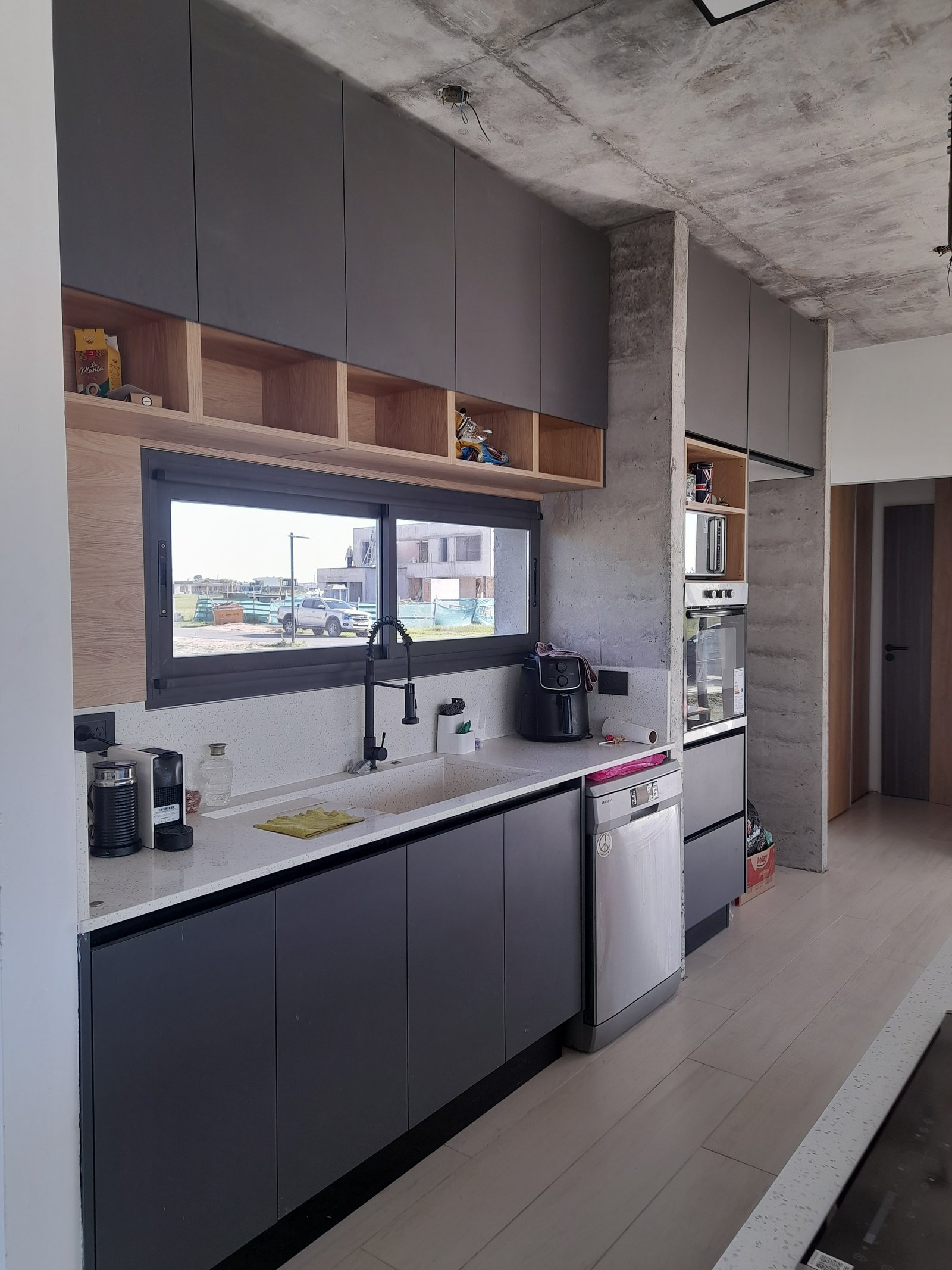 Cozinha moderna industrial com armários cinza e teto de concreto — projeto Puerto Nizuc, por Estudio Fernandez Long & asoc., em Au Dr. Ricardo Balbín km 31.5