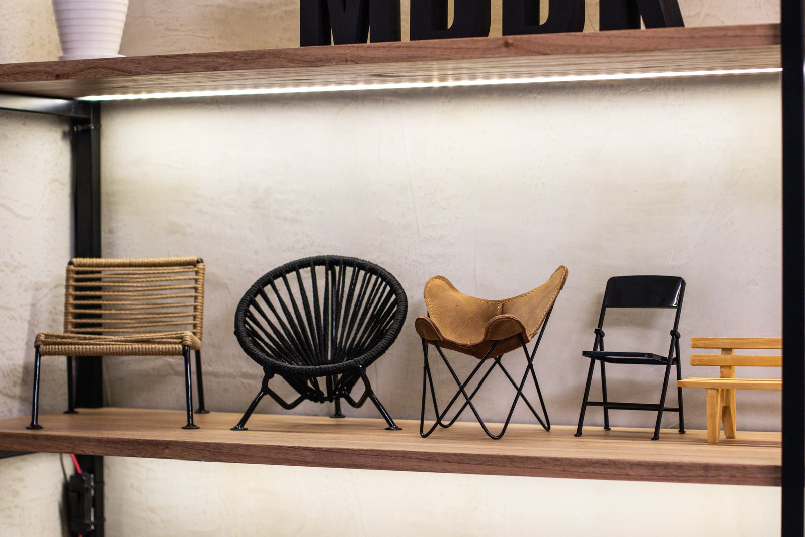 Exhibición de sillas de diseño en local comercial — proyecto Estudio MDBK, por MDBK Arquitectura, en Almagro