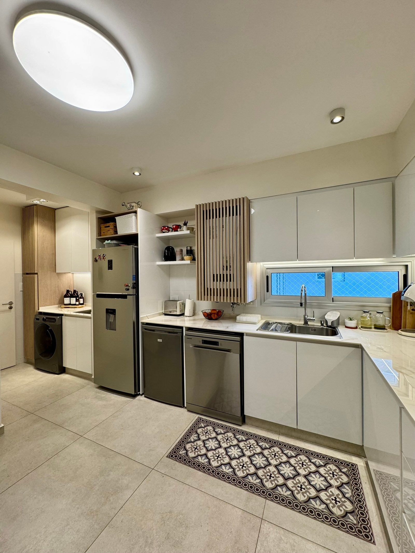 Cozinha escandinava moderna com ilha grande e eletrodomésticos integrados — projeto Corrientes I, por MDBK Arquitectura, em Villa Crespo