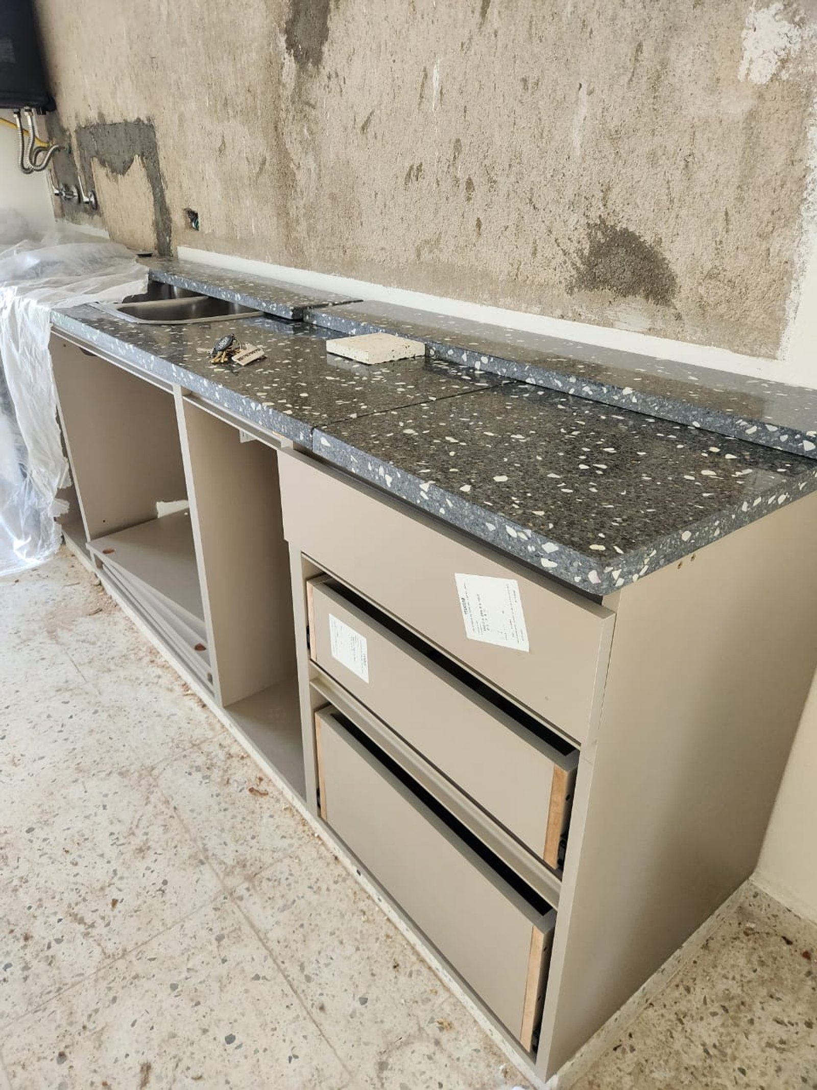 cozinha em construção com bancada de terrazzo e móveis bege — projeto PROYECTO MJC, por Todo con A, em X5125 Monte Cristo