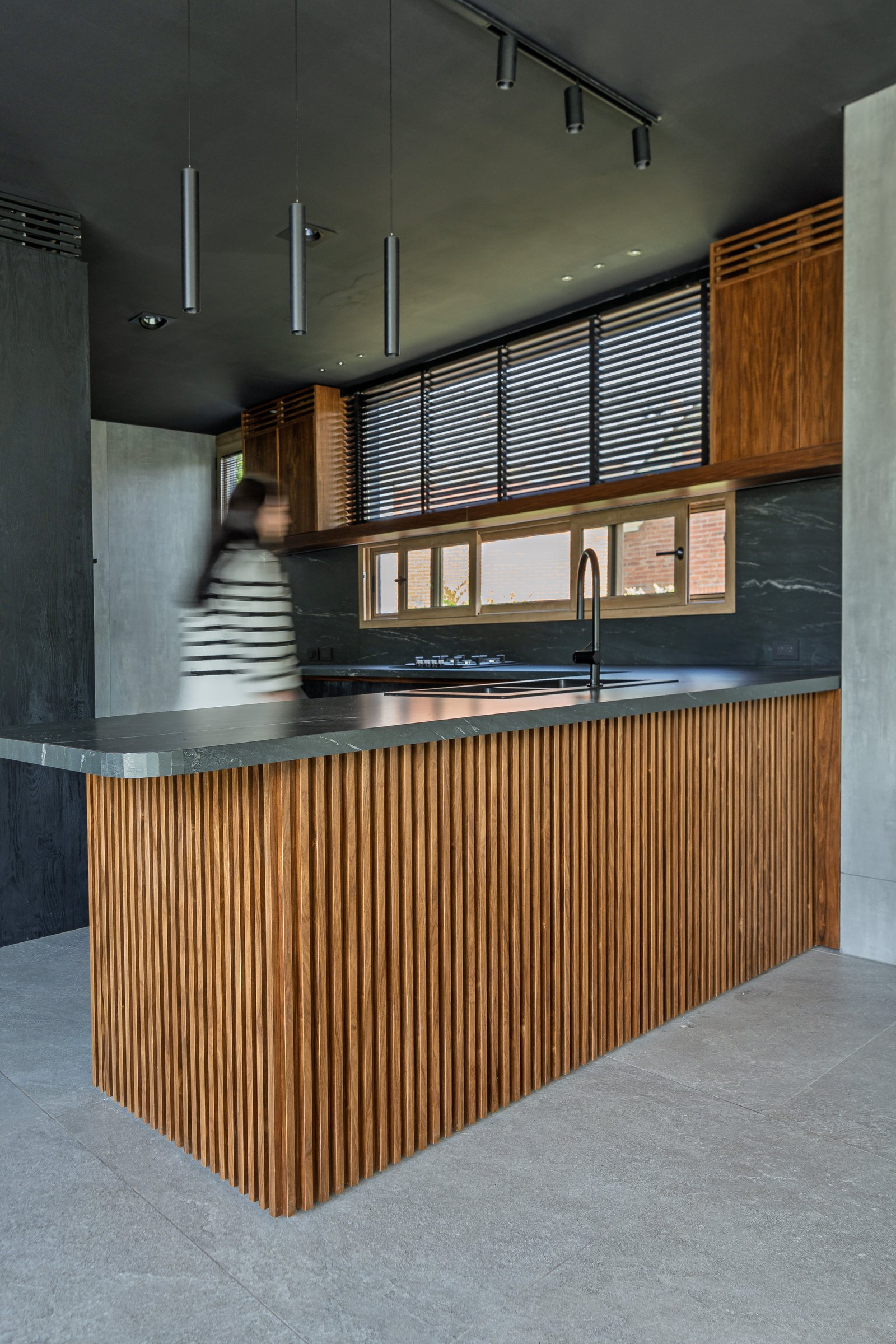 Cozinha moderna com ilha de madeira ripada e teto preto — projeto Castores - Estudio Gambotto, por ABEJA CONCEPT, em Los Castores