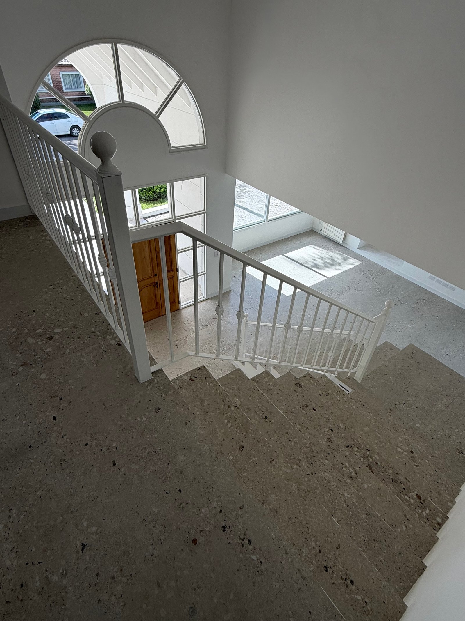 Escada flutuante moderna com janela em arco e piso de terraço — projeto CASA LA CASUALIDAD, por Estudio Grupo 32, em Pilar