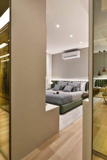 Dormitorio moderno con cama verde, vestidor integrado y doble altura — proyecto Decorado Cumaru, por Pricila Dalzochio