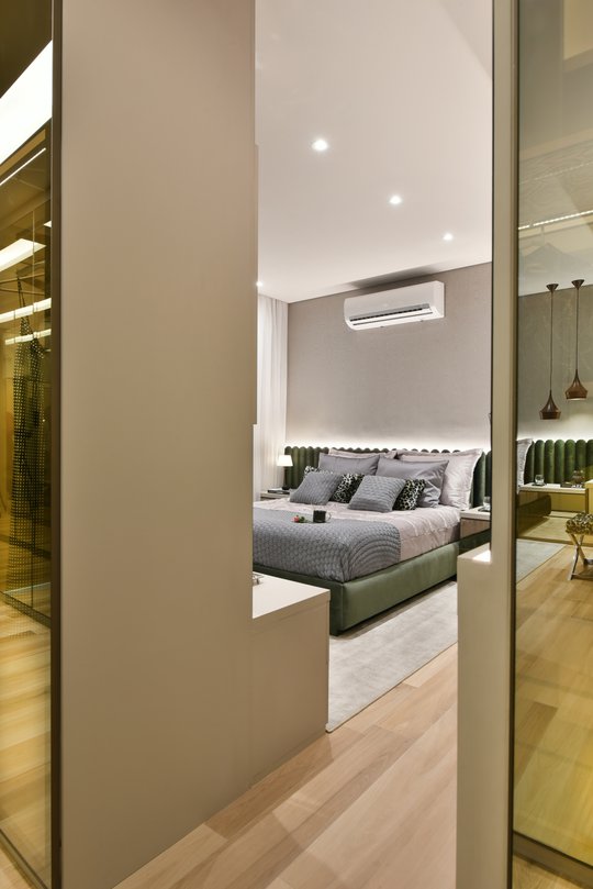 Dormitorio moderno con cama verde, vestidor integrado y doble altura — proyecto Decorado Cumaru, por Pricila Dalzochio