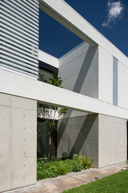 Fachada moderna de hormigón con volúmenes geométricos y patio interior — proyecto CASA SD28, por GMARQ, en Buenos Aires