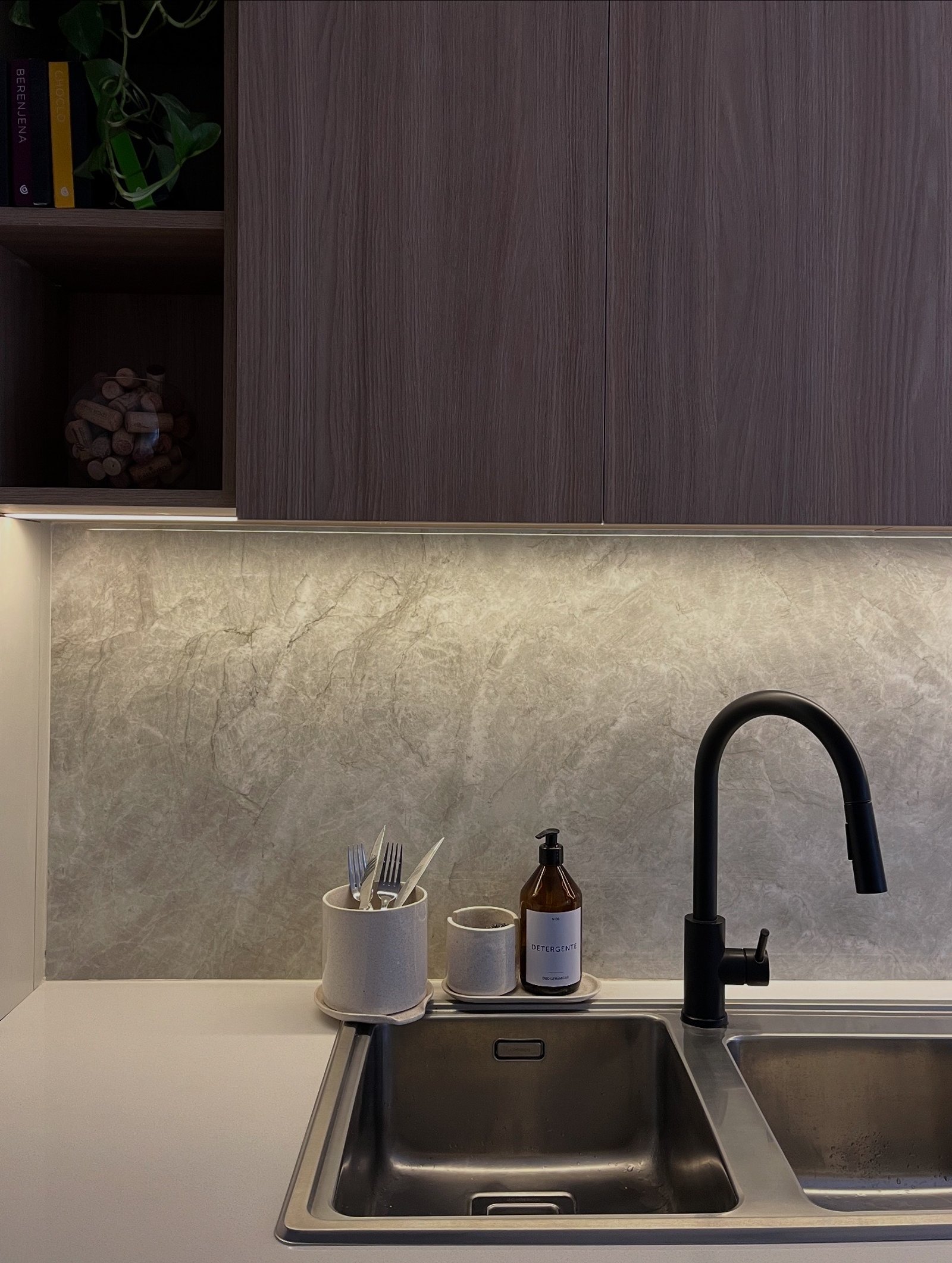 Cocina moderna con muebles de madera oscura y grifería negra — proyecto CASA ANSA, por Barū Arquitectura, en B1674 Sáenz Peña