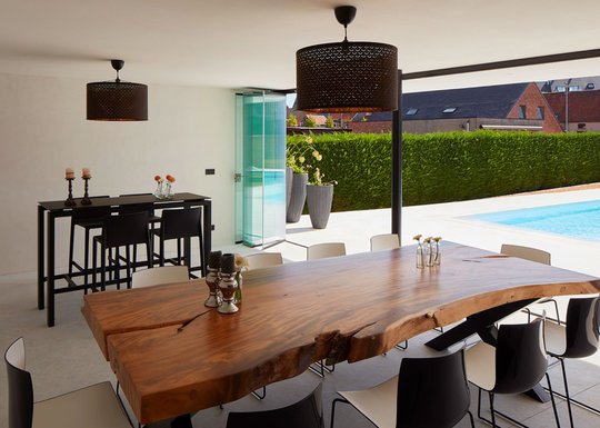 Comedor moderno con mesa madera y vista a pileta exterior — proyecto QUINCHO - PARRILLA , por CERRAMIENTOS PANORAMICOS, en Canning