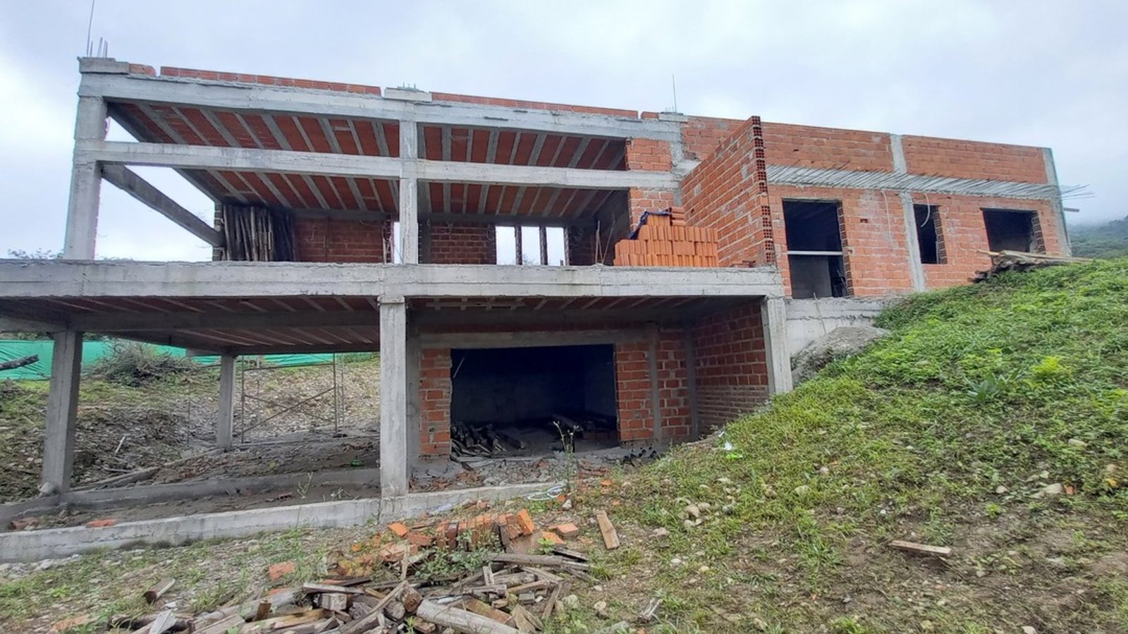casa en construcción con estructura de hormigón y ladrillos — proyecto Casa Las Vertientes, por Luciana González Anderson, en Salta