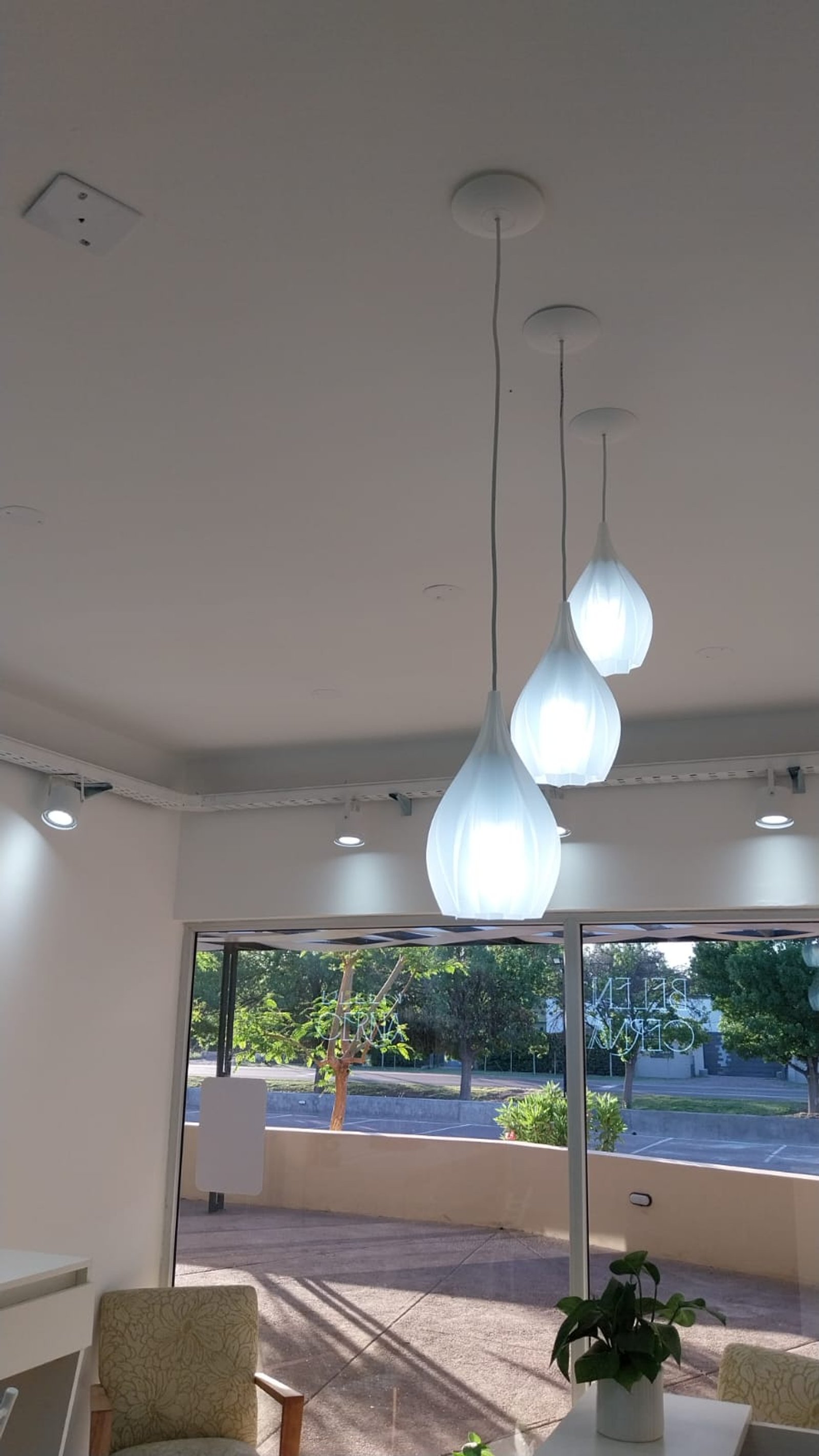 Interior moderno com pendentes brancos e grande janela — projeto BC ESTETICA, por Yamil Cerna, em San Martín