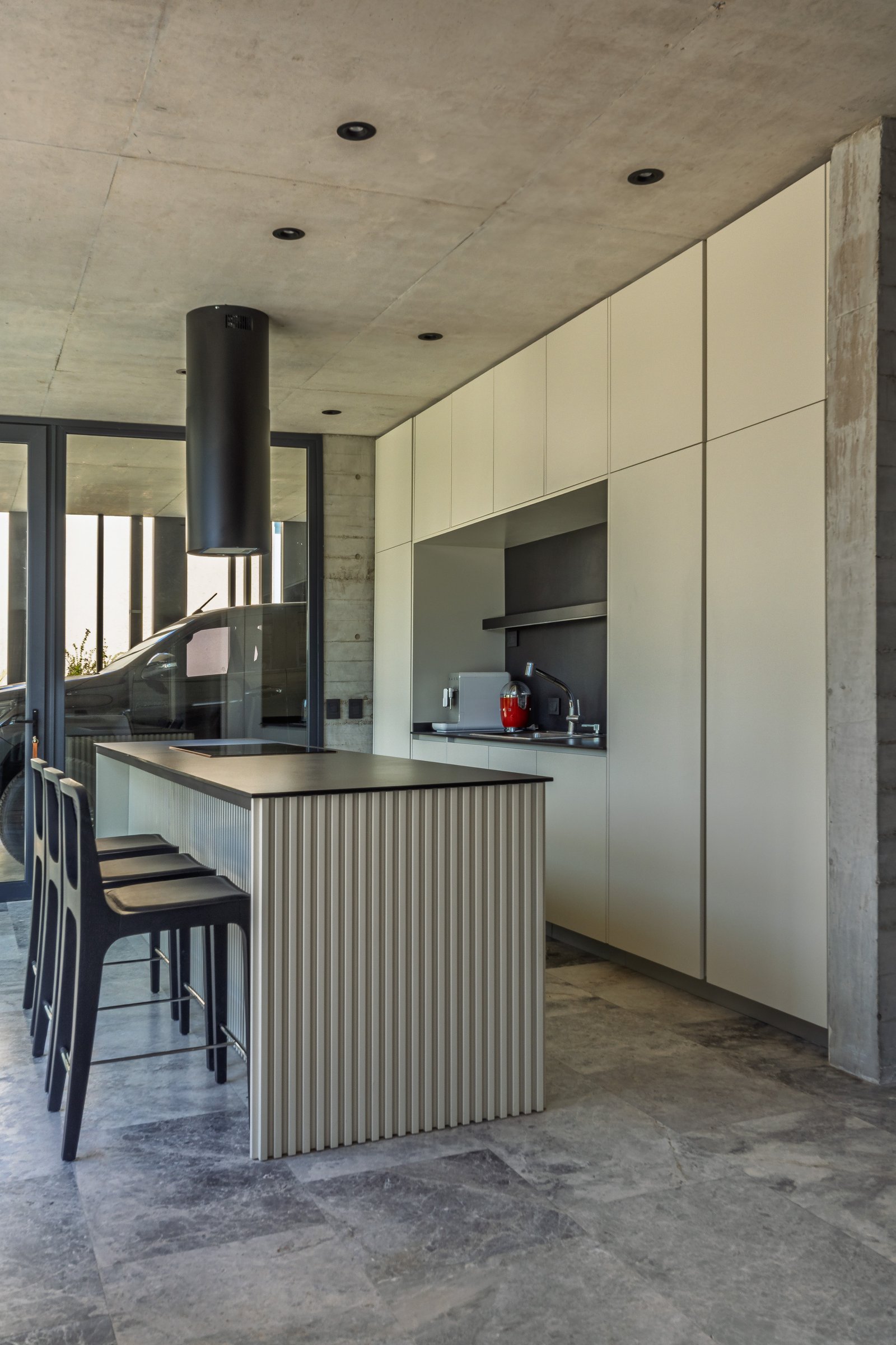 Cozinha moderna com ilha e teto de concreto aparente — projeto La Martona - Estudio Barcelona, por ABEJA CONCEPT, em Cañuelas