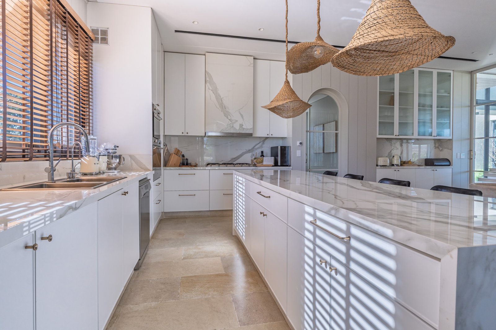 Cozinha moderna aberta estilo mediterrâneo com ilha e pendentes de rattan — projeto PilarA - Estudio Pacifica, por ABEJA CONCEPT, em Pilar