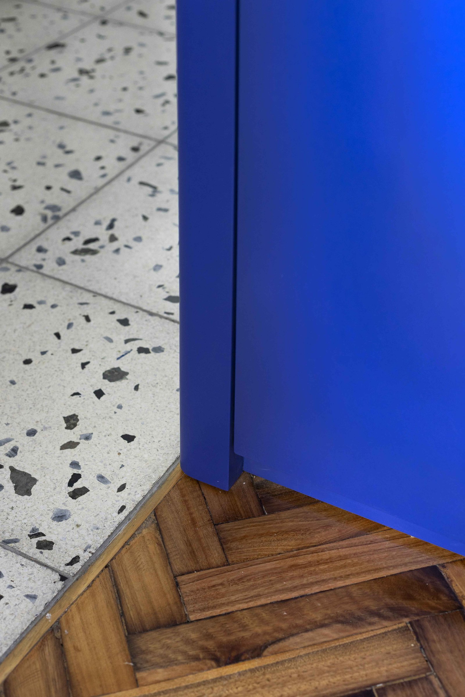 parede azul vibrante e pisos combinados — projeto Julián Alvarez, por Bouré Studio, em Palermo