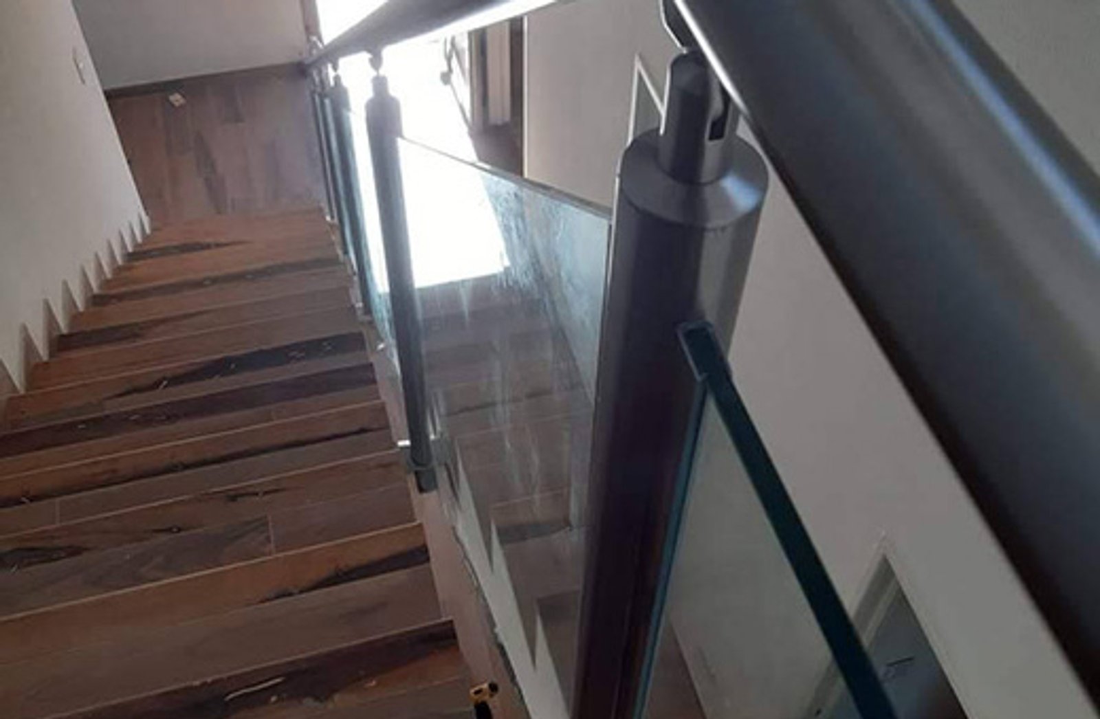 escalera moderna con baranda de vidrio y madera — proyecto Baranda en acero, por Cristalcenter, en Nordelta